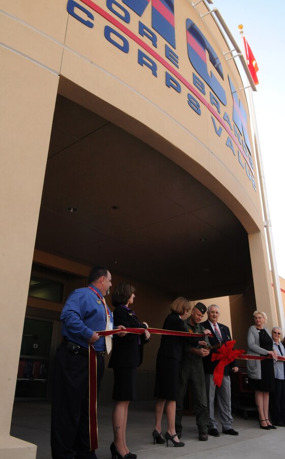 Cindy Lacy-Whitman, head of Marine Corps retail operations, station commanding officer Col. Mark Werth and Don Mitchell, Marine Corps Community Services director, cut the ribbon to open the new Marine Corps Exchange at the Marine Corps Air Station in Yuma, Ariz., Nov. 18, 2009. The 64,000-square-foot exchange, recently completed after approximately 14 months of construction, features a food court, barber shop, laundromat and dry cleaners. Approximately 800 patrons lined up, some as early as the night before, in order to receive a gift bag and a gift card of up to $250. “Oh, it was totally worth it,” said Kyle Hausner, a Marine dependent, who secured his place in line at 11:30 p.m. the previous night. “I only got one or two hours of sleep.” The ribbon-cutting was the first event of the four-day grand opening, which will last through Nov. 21, 2009. “We worked on this event for about two months,” said Jenifer Larson, MCCS assistant marketing director. “The turnout for this has been amazing.”