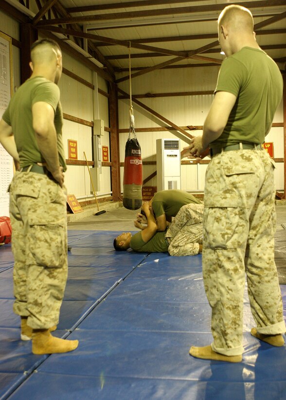 Two Marines from 8th Communications Detachment look on as two others go through gray belt sustainment drills during their green belt Marine Corps Martial Arts Program course aboard Al Asad Air Base, Iraq, Nov. 19, 2009. The Marines in the unit have been working their way through each belt level during their year-long deployment to enhance their skills as well-rounded Marines.  (U.S. Marine Corps photograph by Cpl. Triah Pendracki)