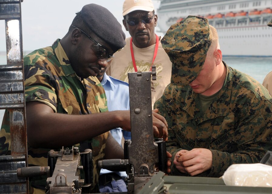 United States Marine Corporal Ragland attached to Security Cooperation Marine Air Ground Task Force (SCMAGTF) and Jamaican Defense Forces Coast Guard Ordinary Seaman Andre Grant perform maintenance on a .50 cal. machine gun on the bed of a truck at Reynolds Pier in Ocho Rios, Jamaica, Nov. 19, 2009, to improve regional security through military to military training. USS Wasp (LHD 1) is currently deployed on Southern Partnership Station-Amphib with Destroyer Squadron 40 and embarked SCMAGTF. Southern Partnership Station is part of the Partnership of the Americas Maritime Strategy that focuses on building interoperability and cooperation in the region to meet common challenges. (U.S. Navy Photo by Mass Communication Specialist 3rd Class Edward L. Kobobel III/Released)::r::::n::