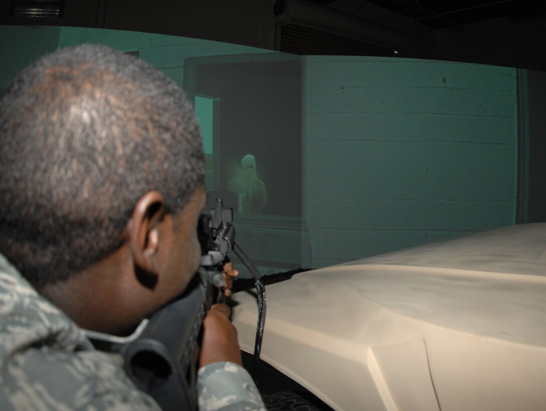 ANDERSEN AIR FORCE BASE, Guam - Staff Sgt. Derrick Spencer, 36th Wing Public Affairs NCO-in-charge of broadcasting, fires a replica M4 Carbine automatic rifle at a simulated target at the Warrior Skills Trainer Nov. 19. The $4 million simulator supports several weapon platforms compatible with the simulator, including the M4 Carbine automatic rifle, the MK19 grenade launcher, the M249 Squad Automatic Weapon and the M2 Browning heavy machine gun. (U.S. Air Force photo by Senior Airman Shane Dunaway)