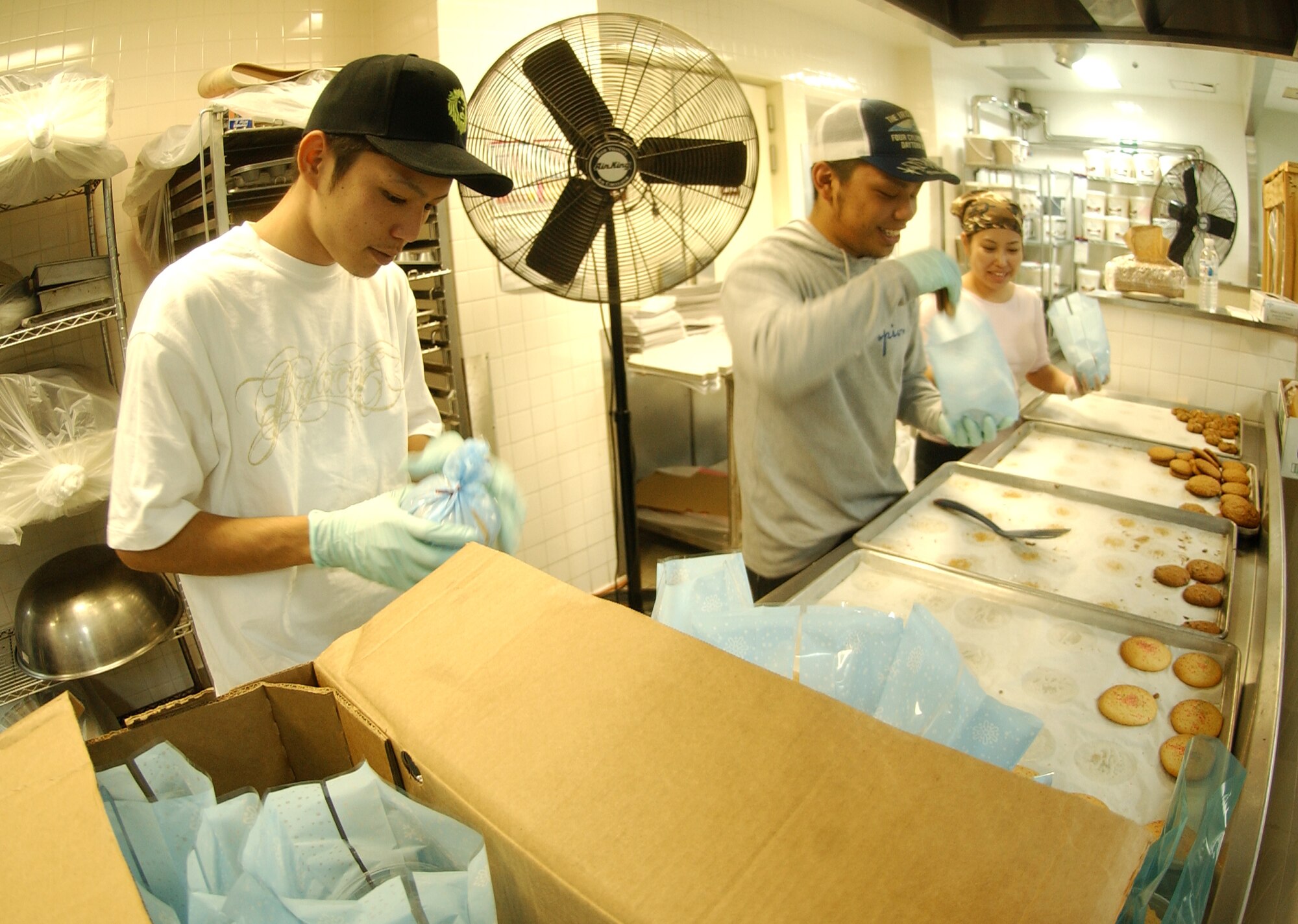 Students from Nikkei Business School and Miyano Yabiko, teacher (far right), package cookies for service members living in the dorms at Kadena Air Base, Nov. 18. The Hometown Kadena Cookie Drive volunteers prepared more than 24,000 cookies that will be delivered Dec. 14 by First Sergeants and other representatives to dorm residents. "It's our way of giving them a little taste of home," said Mrs. Sheri Fletcher.
(U.S. Air Force photo/Tech. Sgt. Rey Ramon) 



