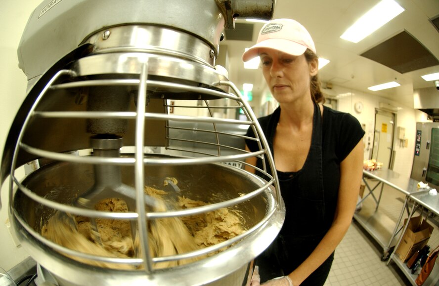 Mrs. Kathy Banks mixes cookie ingredients for students from the Kadena Language Institute and Nikkei Business School to prepare for servicemembers living in the dorms at Kadena Air Base Nov. 18. The Hometown Kadena Cookie Drive volunteers prepared more than 24,000 cookies that will be delivered to dorm residents by first sergeants and other representatives Dec. 14. "It's our way of giving them a little taste of home," said Mrs. Sheri Fletcher, one of the event coordinators. 
(U.S. Air Force photo/Tech. Sgt. Rey Ramon) 
