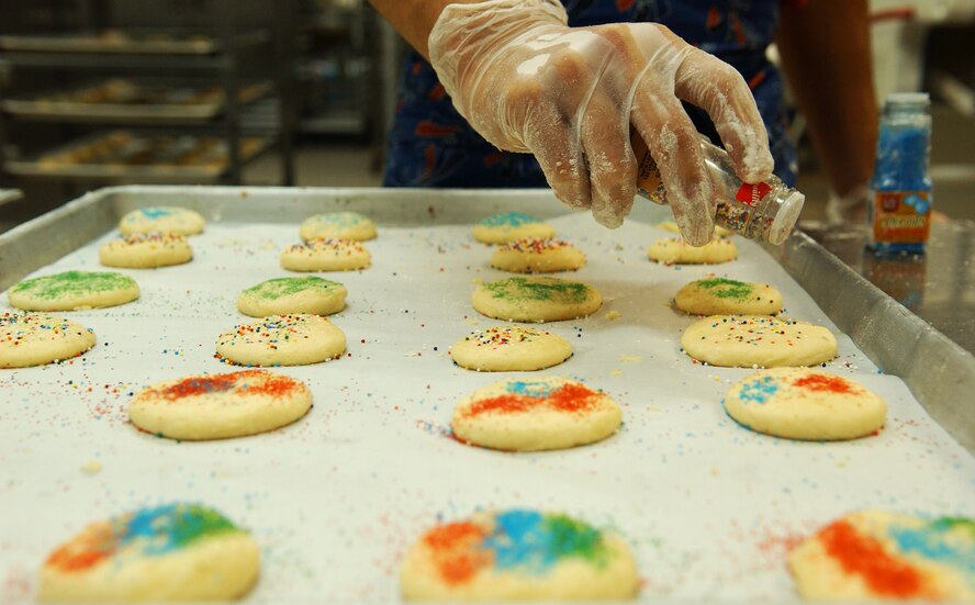 Students from the Kadena Language Institute and Nikkei Business School, along with military dependents, prepare cookies for servicemembers living in the dorms at Kadena Air Base Nov. 18. The Hometown Kadena Cookie Drive volunteers prepared more than 24,000 cookies that will be delivered to dorm residents by first sergeants and other representatives Dec. 14. "It's our way of giving them a little taste of home," said Mrs. Sheri Fletcher, one of the event coordinators. 
(U.S. Air Force photo/Tech. Sgt. Rey Ramon) 
