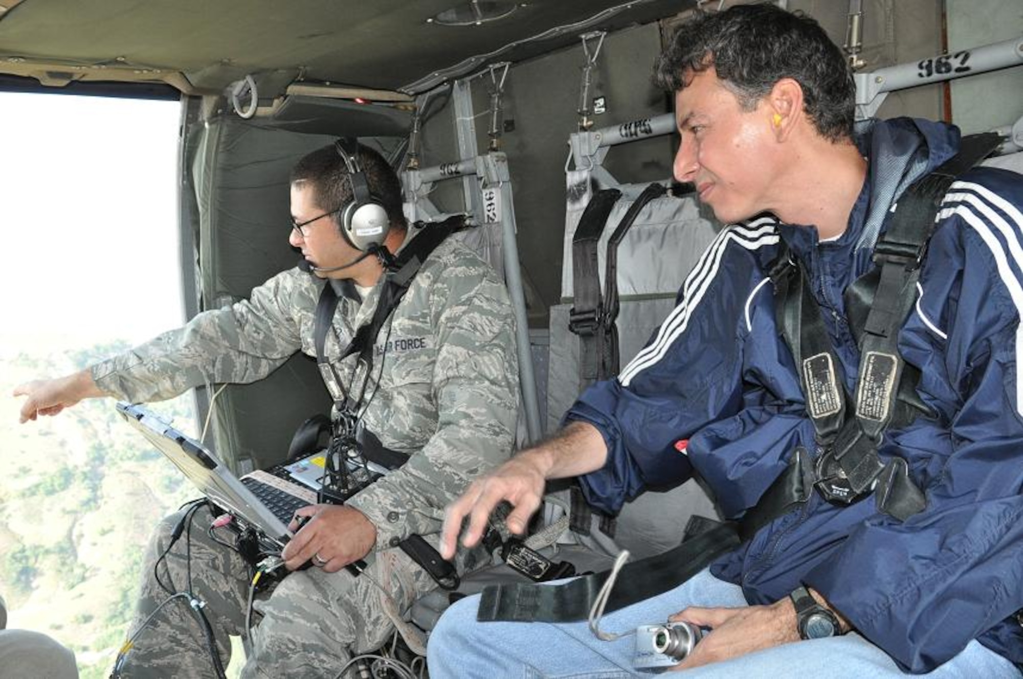 ILOPANGO, El Salvador--Air Force Maj. Leonel Gonzalez, U.S. SOUTHCOM Standing Joint Force Headquarters  Logistics Planner, points out an item of interest to Manuel Diaz, a geologist in El Salvador's Ministry of the Environment, as they conduct a damage assessment mission here Nov. 16. A combined U.S., Salvadoran assessment team is working together to collect data from damage sites and recommend steps to help El Salvador recover from recent floods and landslides. The team conducted aerial reconnaissance, with the support of Joint Task Force-Bravo helicopters, a well as on-the-ground evaluations. (U.S. Air Force photo/1st Lt. Jen Richard)