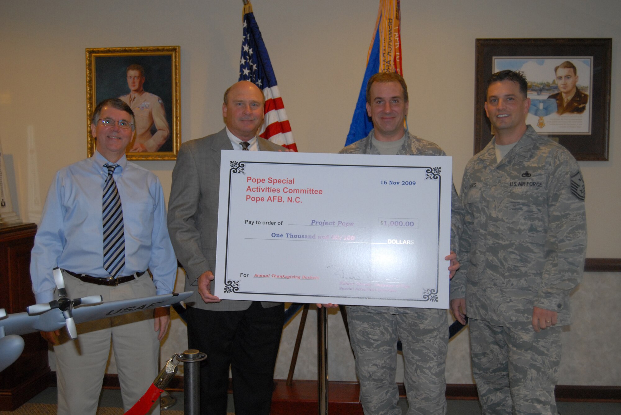 Kenny Burke, far left, Robert Grover, second from left, chairman of PSAC met with Master Sgts. Robert Shafer, 43rd Logistics Readiness Squadron, and Danny Davis, 2nd Airlift Squadron,  to present them with a check for $1,000 to be used in conjunction with Project Hope. (U.S. Photo by Senior Airman Mindy Bloem)