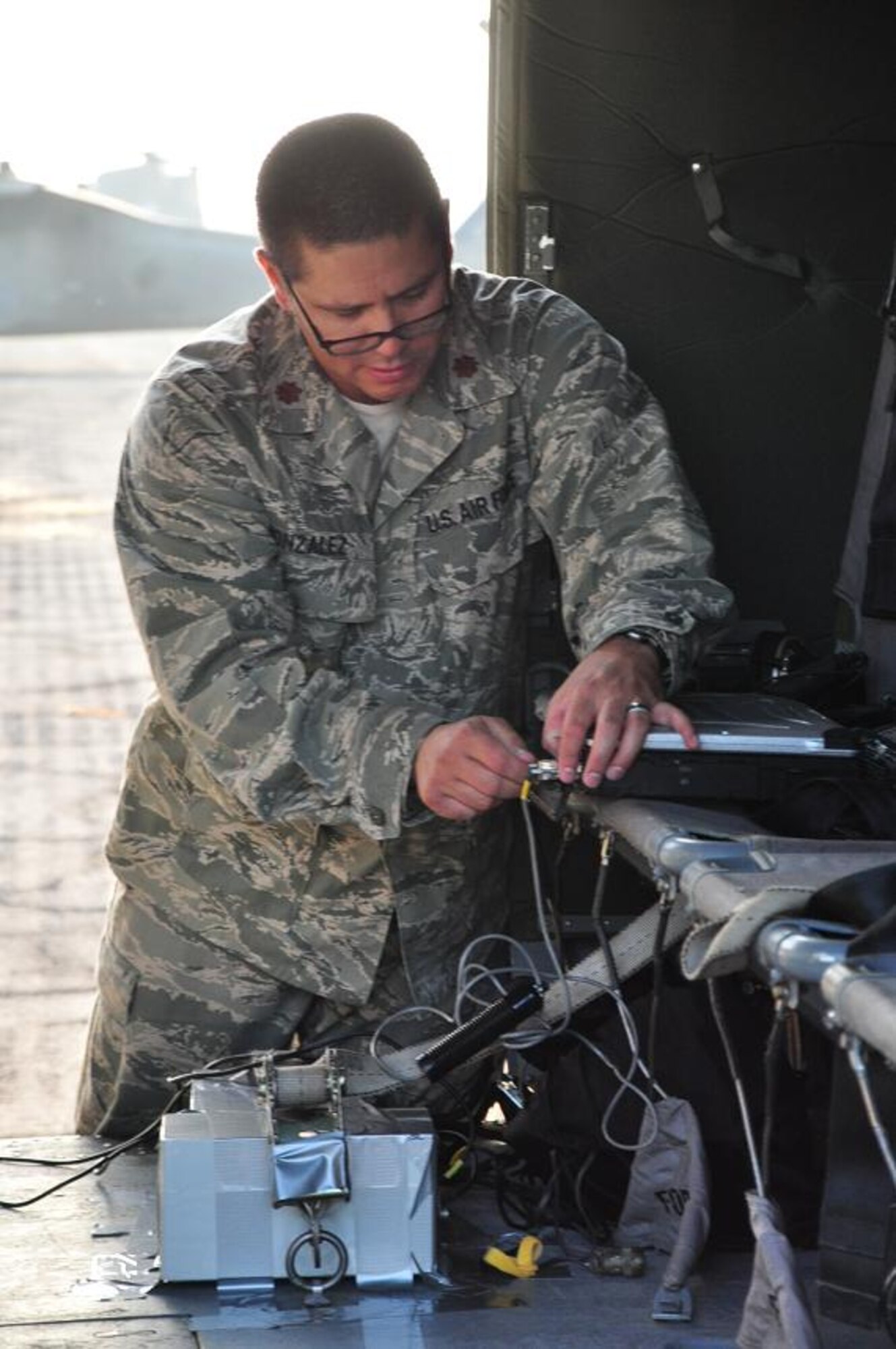 ILOPANGO, El Salvador--Air Force Maj. Leonel Gonzalez, U.S. SOUTHCOM Standing Joint Force Headquarters  Logistics Planner, installs an Automated Route Reconnaissance Kit in a Joint Task Force-Bravo helicopter for a damage assessment mission here Nov. 16. The ARRK, developed by the USACE’s Engineering Research and Development Center, is an easy-to-use system that provides a safe, quick way to gather and process data. A combined U.S., Salvadoran assessment team is working together to collect data from damage sites and recommend steps to help El Salvador recover from recent floods and landslides. (U.S. Air Force photo/1st Lt. Jen Richard)