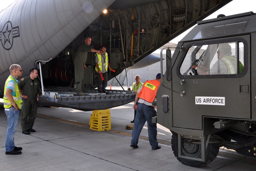 TEL AVIV, Israel -- Air Force Reserve Master Sgt. Bryan Watson, a loadmaster assigned to the 910th Airlift Wing, based at Youngstown Air Reserve Station, Ohio, directs the driver of a "K-loader," as the cargo handling vehicle approaches the cargo ramp of a C-130H Hercules tactical cargo transport aircraft, also assigned to YARS, on the tarmac of Ben Gurion International Airport here, October 25, 2009. Segreant Watson and a group of eight other 910th Citizen Airmen have just delivered 29 passengers and their baggage to Tel Aviv on an airlift mission from Naples Naval Air Station, Italy. The 910th Airmen are scheduled to pick up four single pallets and a double pallet of cargo here and deliver them to Ramstein Air Base, Germany. The aircrew members completing this airlift mission are among more than 70 Servicemembers from YARS attached to the 38th Expeditionary Airlift Squadron, based at Ramstein. The 38th EAS is supporting Operation Joint Enterprise by providing tactical airlift capability to locations in the U.S. Europe Command (EUROCOM), U.S. Africa Command (AFRICOM) and U.S. Central Command (CENTCOM) theaters of operations. U.S. Air Force photo by Master Sgt. Bob Barko Jr.