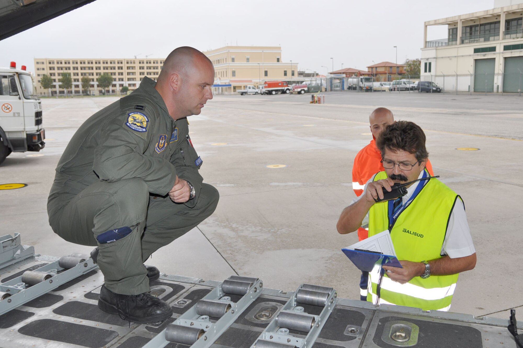 NAPLES NAVAL AIR STATION, Italy -- Air Force Reserve Capt. Brian Hodor, a pilot assigned to the 773rd Airlift Squadron, based at Youngstown Air Reserve Station, Ohio, talks with Rino Montone, the supervisor of the Air Terminal Operations Center here, October 24, 2009. Capt. Hodor and Mr. Montone are coordinating the pick up of passengers being flown to Ben Gurion Airport in Tel Aviv, Israel aboard the C-130H Hercules tactical cargo transport aircraft that Capt. Hodor piloted to Naples. He and the eight other Citizen Airmen flying on this airlift mission are among more than 70 Servicemembers from YARS attached to the 38th Expeditionary Airlift Squadron, based at Ramstein. The 38th EAS is supporting Operation Joint Enterprise by providing tactical airlift capability to locations in the U.S. Europe Command (EUROCOM), U.S. Africa Command (AFRICOM) and U.S. Central Command (CENTCOM) theaters of operations. U.S. Air Force photo by Master Sgt. Bob Barko Jr. 