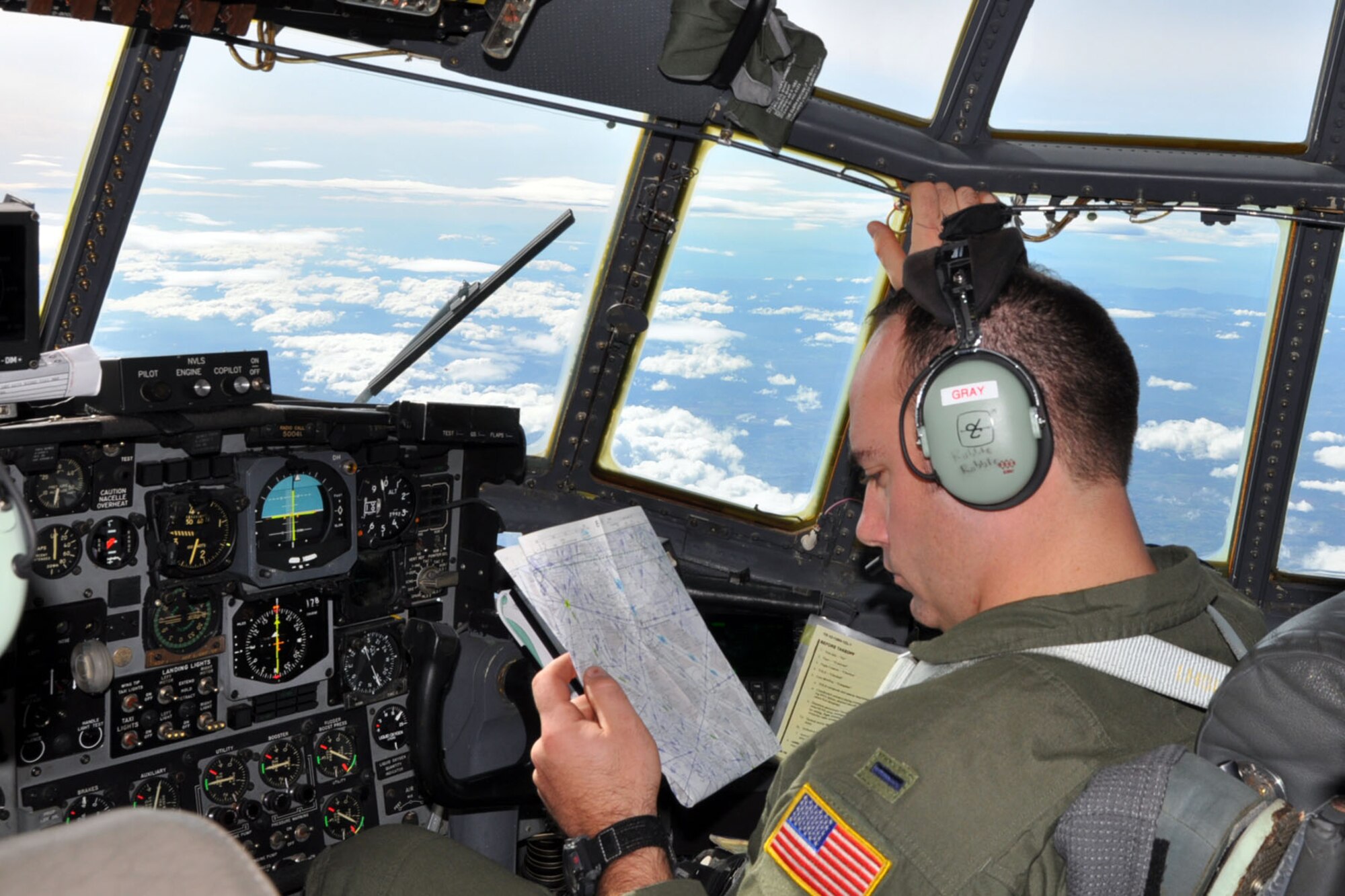 SOMEWHERE OVER NORTHERN ITALY -- Air Force Reserve pilot 1st Lt. Ryan Gray studies a navigation chart as he sits in the co-pliot chair on the flight deck of a C-130H Hercules tactical cargo transport aircraft assigned to the 910th Airlift Wing, based at Youngstown Air Reserve Station, Ohio. Lieutenant Gray and eight other Citizen Airmen from YARS are flying to Naples Naval Air Station, Italy to pick up 29 passengers and their baggage and deliver them to Ben Gurion Airport in Tel Aviv, Israel. The Italian coastline on the Ligurian Sea can be seen in the dictance out of the C-130's cockpit windows. The aircrew members flying on this airlift mission are among more than 70 Servicemembers from YARS attached to the 38th Expeditionary Airlift Squadron, based at Ramstein. The 38th EAS is supporting Operation Joint Enterprise by providing tactical airlift capability to locations in the U.S. Europe Command (EUROCOM), U.S. Africa Command (AFRICOM) and U.S. Central Command (CENTCOM) theaters of operations. U.S. Air Force photo by Master Sgt. Bob Barko Jr. 