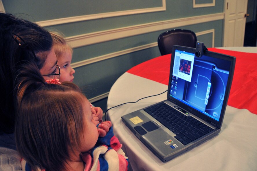 OFFUTT AIR FORCE BASE, Neb. - Jenny Enloe, wife of Staff Sgt. Joshua Enloe, sits with her children 3-year-old Abbie and 16-month-old Chloe while recording a video message during Holiday Connections Nov. 17 in the Patriot Club. The event, established in 2000, provides support for the loved ones of military members deployed during the holiday season. U.S. Air Force photo by Jeff W. Gates 
