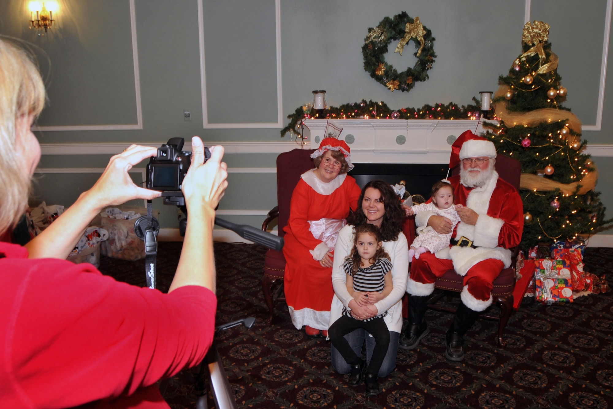 OFFUTT AIR FORCE BASE, Neb. - Devon Cutinella, wife of Maj. Andrew Cutinella with the 38th Reconnaissance Squadron, and her daughters 5-month-old Ashlynn and 4-year-old Ava pose for a photo with Santa and Mrs. Claus during Holiday Connections Nov. 17 at the Patriot Club.  The event, established in 2000, provides support for the loved ones of military members deployed during the holiday season. U.S. Air Force photo by Jeff W. Gates