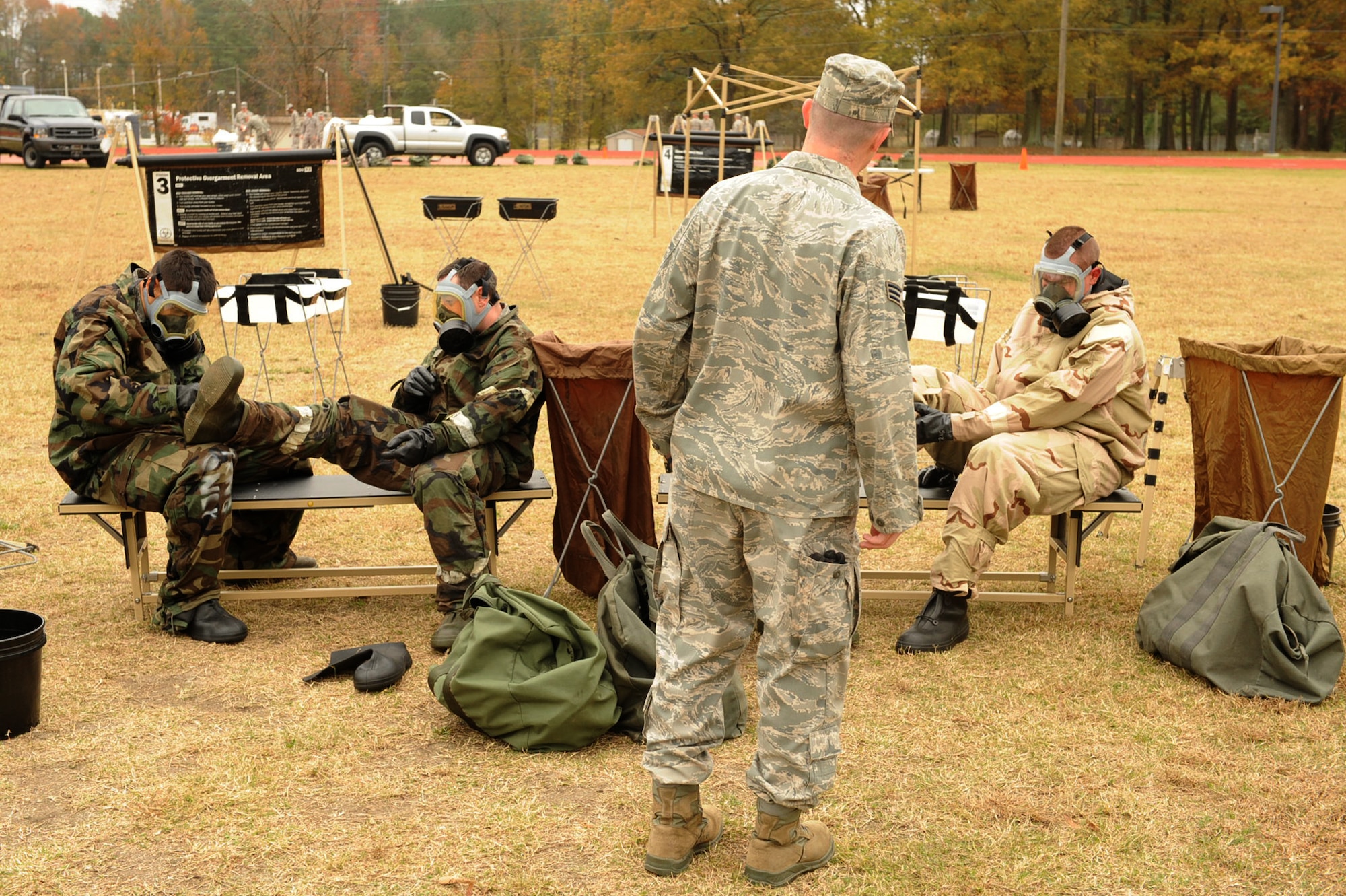 Airmen use the buddy system at a protective over garment removal area during an ability to survive and operate training session on Seymour Johnson Air Force Base, N.C., Nov. 18, 2009. The focus of the ATSO training was to teach Airmen who have not been key players during an exercise on how to operate in a chemical environment. (U.S. Air Force photo/Senior Airman Ciara Wymbs) 