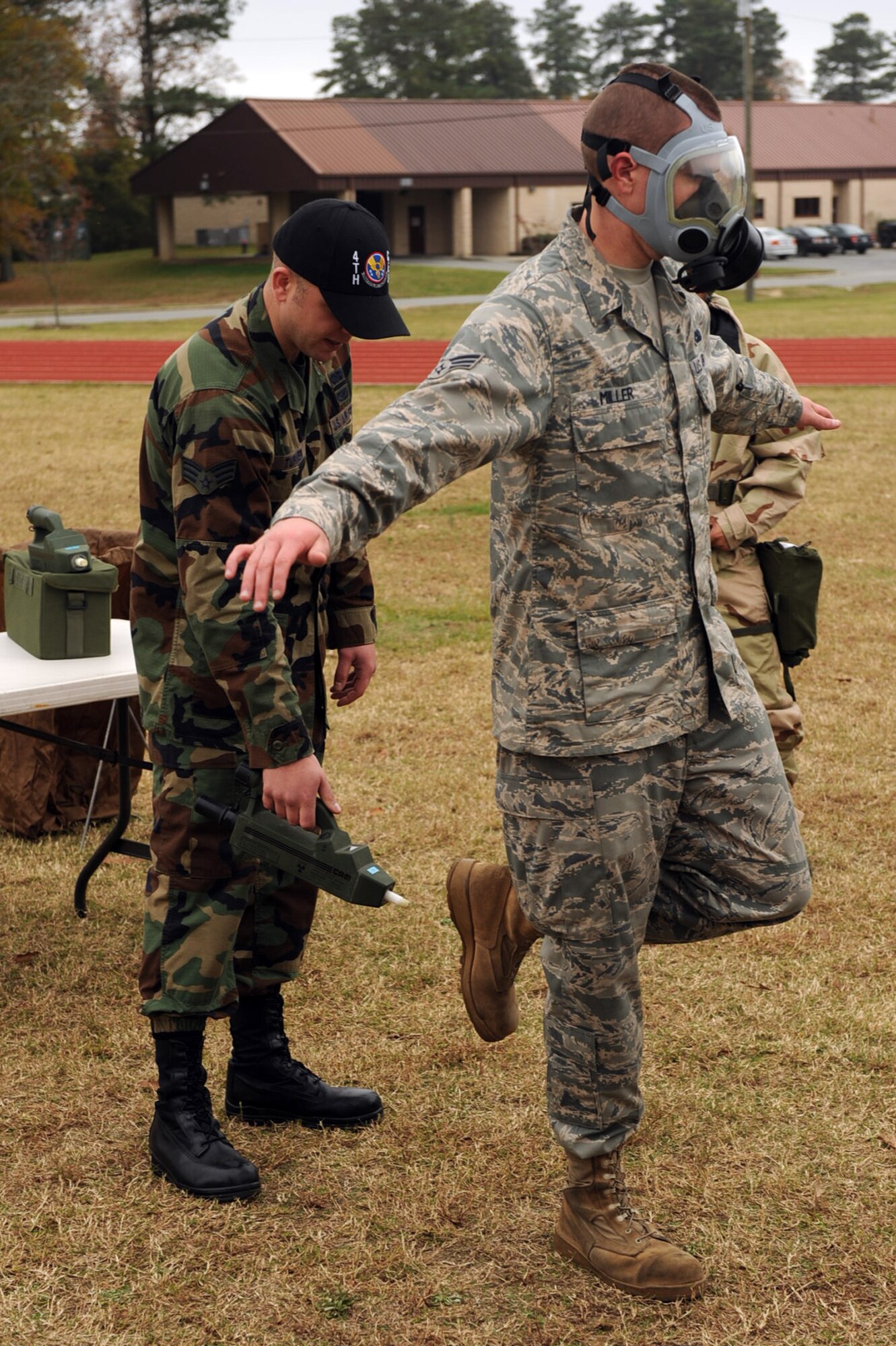 Senior Airman Mark Turner, 4th Civil Engineer Squadron readiness and emergency management journeyman, scans the boots of Senior Airman Christopher Miller, 4th Logistics Readiness Squadron vehicle operations specialist, for simulated contamination at the mask monitoring removal area during an ability to survive and operate training on Seymour Johnson Air Force Base, N.C., Nov. 18, 2009. During the course, Airmen went through five steps of the decontamination process to include the removal of external equipment such as the hood, protective over garment and gloves while staying aware of the mask, avoiding contamination. (U.S. Air Force photo/Senior Airman Ciara Wymbs) 
