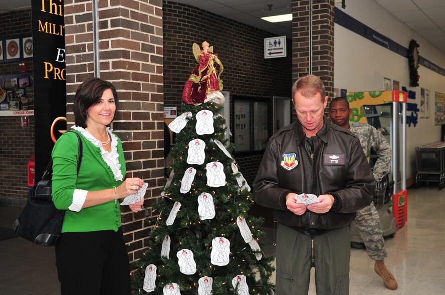Col. Mark Kelly, 4th Fighter Wing commander, and his wife Tanya read about the children they will help this holiday season through the Angel Tree in the Seymour Johnson Air Force Base Exchange, Nov. 17, 2009. The Angel Tree will stand in the BX until Dec. 17 when the Company Grade Officers Council will collect and sort all the donated gifts. (U.S. Air Force photo/Airman 1st Class Rae Perry)