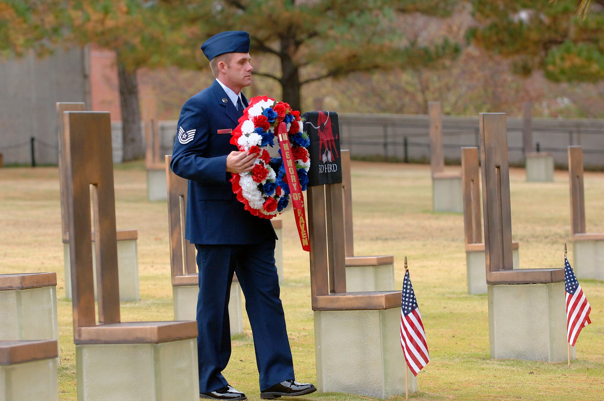 Tech Sgt. Jeffrey Anderson, 32nd Combat Communications Squadron, wreath-bearer for Airman 1st Class Cartney Jean McRaven, moves toward the memorial chair for Airman McRaven during the Veterans Day wreath laying ceremony at the Oklahoma City National Memorial. (Air Force photo by Dave Faytinger)