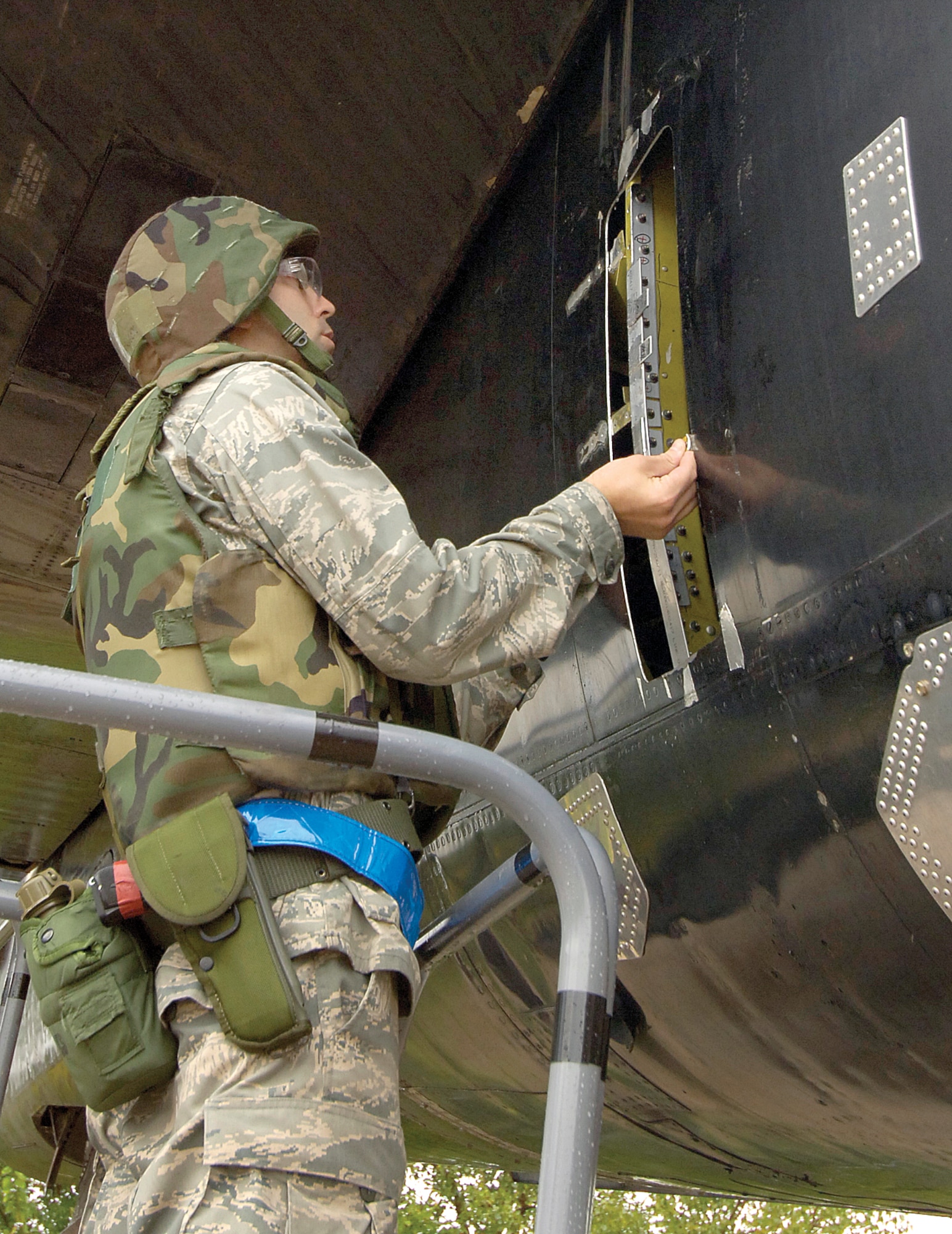 During an exercise, 1st Lt. Andrew Sturgeon measures a simulated battle-damaged B-52 to calculate the stress load of the area so he can design a repair for the expeditionary repair technicians. Lieutenant Sturgeon normally works in the Engineering Directorate, but is an aircraft battle damage repair-deployable engineer. The design is a recipe for repair, telling mechanics what materials are needed, including bolt patterns, patches and metals to use. (Air Force photo by Margo Wright)