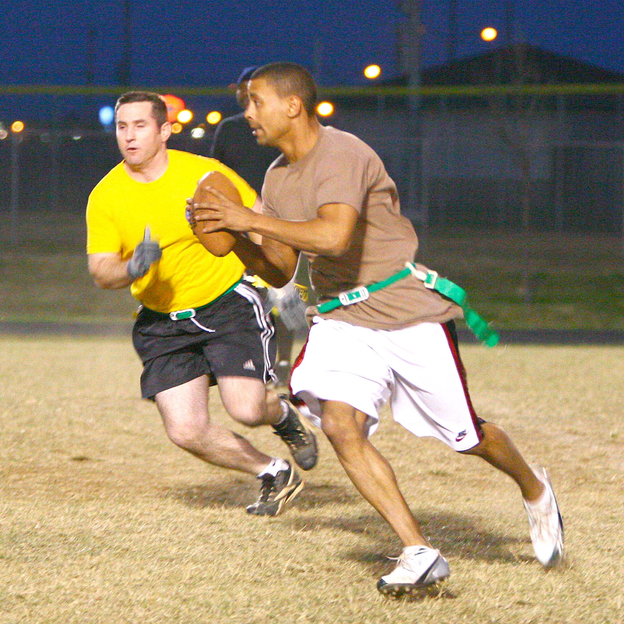 William Grigsby, 552nd Aircraft Maintenance Squadron quarterback, scrambles away from a rushing 965th Airborne Air Control Squadron defender during the teams’ Nov. 13 game. The 552nd AMXS team came away with a big 28-8 win, earning a spot in the playoffs with their 4-2 record.