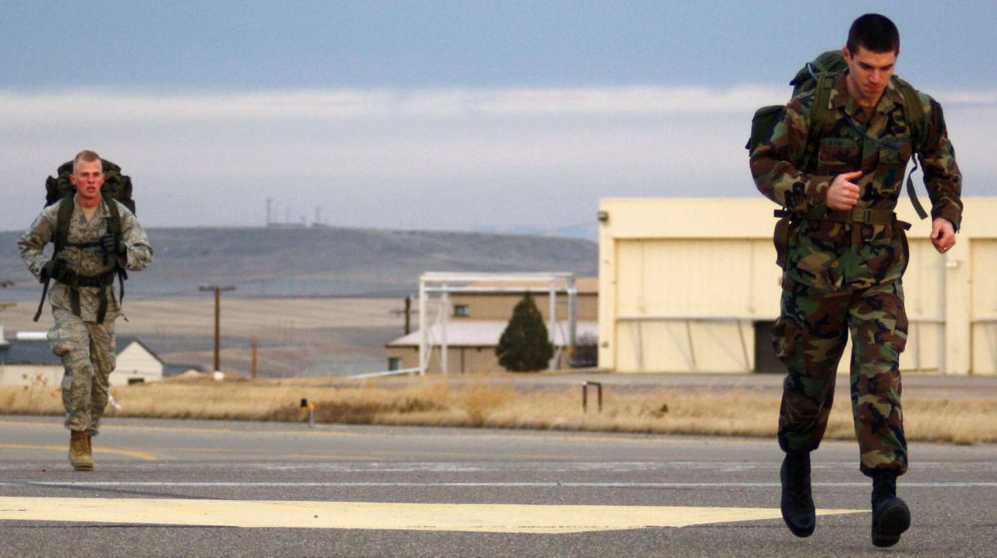 (from L to R) 2nd Lt. Stephen Zeglen and 2nd Lt. William Glojek jog up hill on a five-mile course carrying 45-pound ruck sacks for the 341st Security Forces Group's "Ruck Up and Remember" Veterans Day road march Nov. 11, 2009.