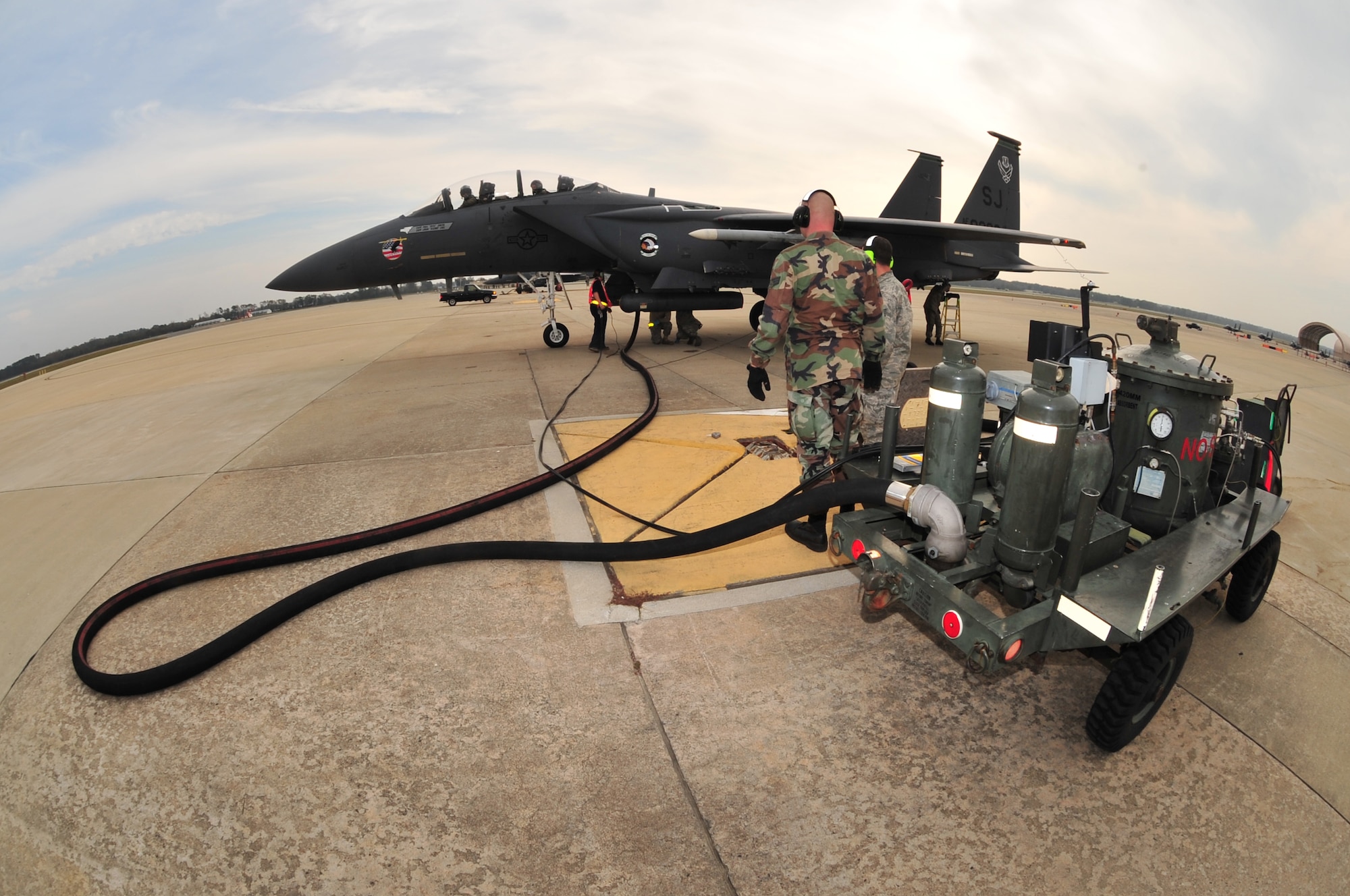 An F-15E Strike Eagle waits on the hot pit pads while Airmen from the 4th Aircraft Maintenance Squadron and the 4th Logistic Readiness Squadron refuel the jet for a quick-turn sortie on Seymour Johnson Air Force Base, N.C., Nov. 17, 2009. During a mission, a pilot can have the jet refueled multiple times to complete his or her objective. (U.S. Air Force photo/Airman 1st Class Rae Perry) 