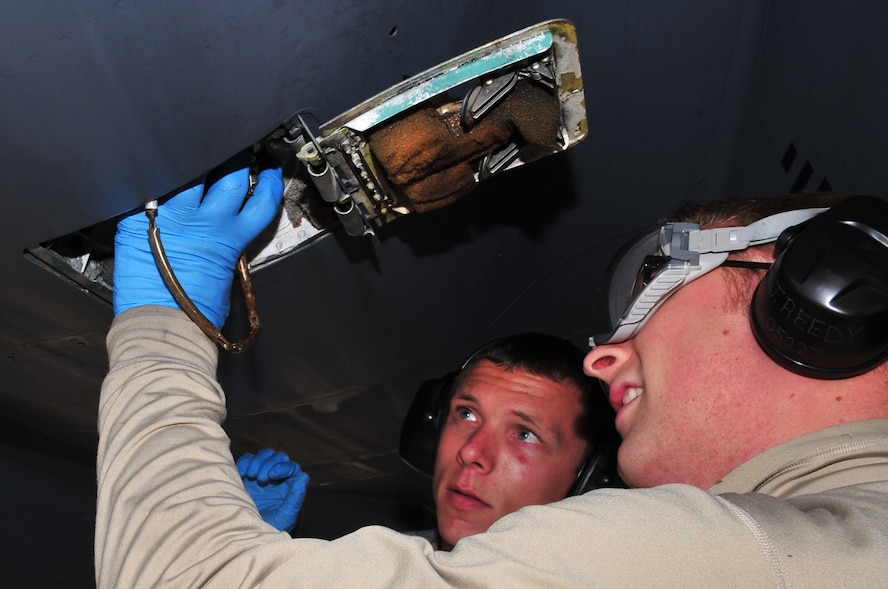 Airman 1st Class Johnathan Reedy (front), 4th Aircraft Maintenance Squadron avionics apprentice, removes a fuel cap with the assistance of Senior Airman Phillip Butche, 4th AMXS specialist flight, during a hot pit at Seymour Johnson Air Force Base, N.C., Nov. 17, 2009. Different 4th AMXS crews perform hot pits each week to keep their certifications current. Airman Reedy hails from Portsmouth, Ohio and Airman Butche is from Indianapolis. (U.S. Air Force photo/Airman 1st Class Rae Perry)