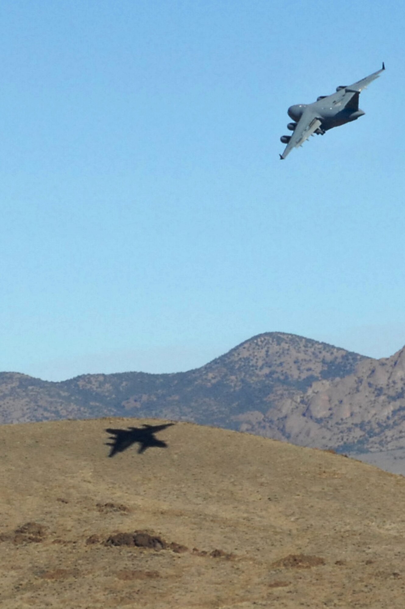 NEVADA TEST AND TRAINING RANGE --  A C-17 Globemaster III circles Keno airfield  runway while preparing to land, Nov. 18.  The aircraft are part of the bi-annual, U.S. Air Force Weapons School Mobility Air Forces Exercise which provides realistic training for combat air force, mobility air force, and U.S. Army personnel.  Approximately 40 C-17s and C-130s from Air Force bases around the United States flew approximately 400 Soldiers from Fort Bragg, NC., for airdrops on the Nevada Test and Training Range.  In addition to providing airdrop training, the exercise also allows Soldiers the opportunity to utilize Range facilities to conduct urban ground operations training.  (U.S. Air Force photo/Staff Sgt. Taylor Worley)(Released)
