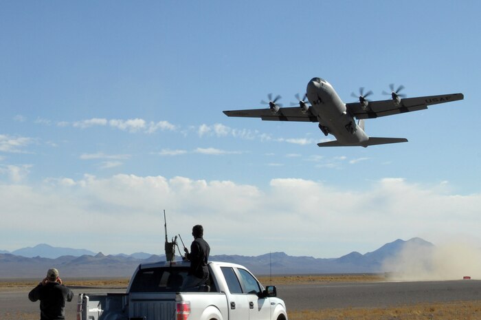 NEVADA TEST AND TRANING RANGE -- U.S. Air Force Combat Controllers look on during the short take off and landing phase of the U.S. Air Force Weapons School Mobility Air Forces Exercise as C-130 Hercules takes off from a dirt landing zone at the Nevada Test and Training Range. The aircraft are part of the bi-annual, U.S. Air Force Weapons School Mobility Air Forces Exercise which provides realistic training for combat air force, mobility air force, and U.S. Army personnel.  Approximately 40 C-17s and C-130s from Air Force bases around the United States flew approximately 400 Soldiers from Fort Bragg, NC., for airdrops on the Nevada Test and Training Range.  In addition to providing airdrop training, the exercise also allows Soldiers the opportunity to utilize Range facilities to conduct urban ground operations training.  (U.S. Air Force photo/Staff Sgt. Taylor Worley)(Released)