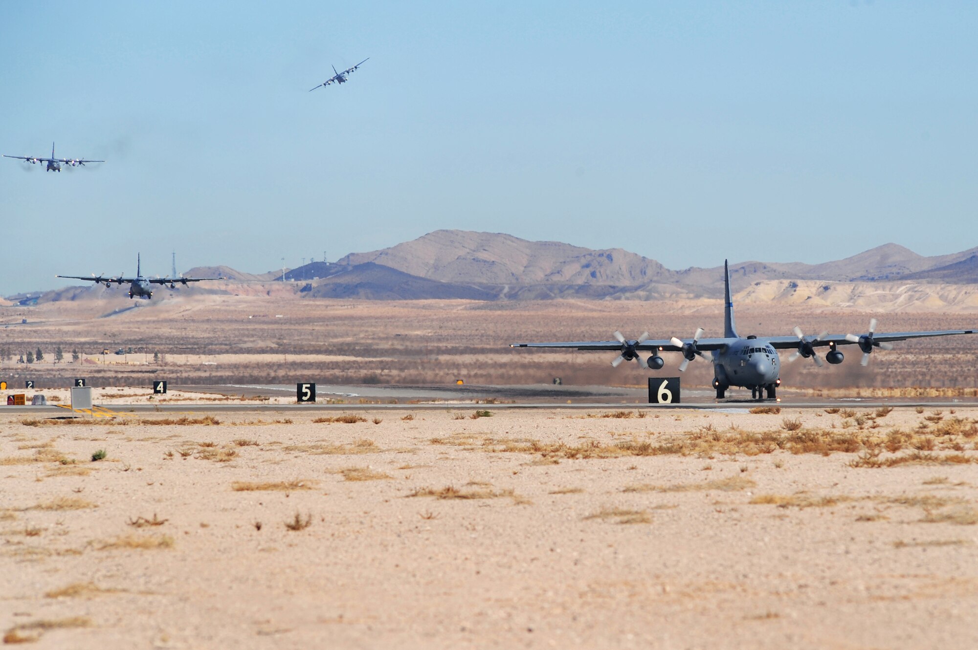 Nellis AIR FORCE BASE, Nev. -- A group of C-130 Hercules aircraft come in for a landing at Nellis Nov. 18.  The aircraft are part of the bi-annual, U.S. Air Force Weapons School Mobility Air Forces Exercise which provides realistic training for combat air force, mobility air force, and U.S. Army personnel.  Approximately 40 C-17s and C-130s from Air Force bases around the United States flew approximately 400 Soldiers from Fort Bragg, N.C., for airdrops on the Nevada Test and Training Range. In addition to providing airdrop training, the exercise also allows Soldiers the opportunity to utilize Range facilities to conduct urban ground operations training.
(U.S. Air Force Photo / Staff Sgt. William P. Coleman)(RELEASED)
