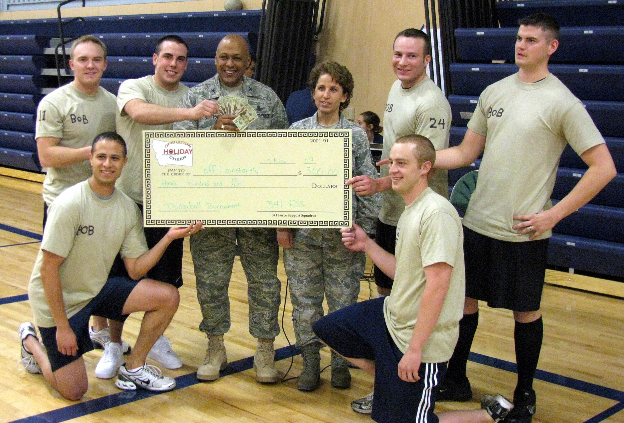 The first of five Operation Holiday Cheer events, a dodge ball tournament, took place Nov. 13 in teh new fitness center. Posing with the first place winning team "Off Constantly" are Col. Anthony Cotton, 341st Missile Wing vice wing commander, and Chief Master Sgt. Cari Kent, 341st Missile Wing command chief master sergeant. The next event is a 9-pin no-tap bowling tournament Nov. 20. (U.S. Air Force photo/Master Sgt. Matthew Carroll.)