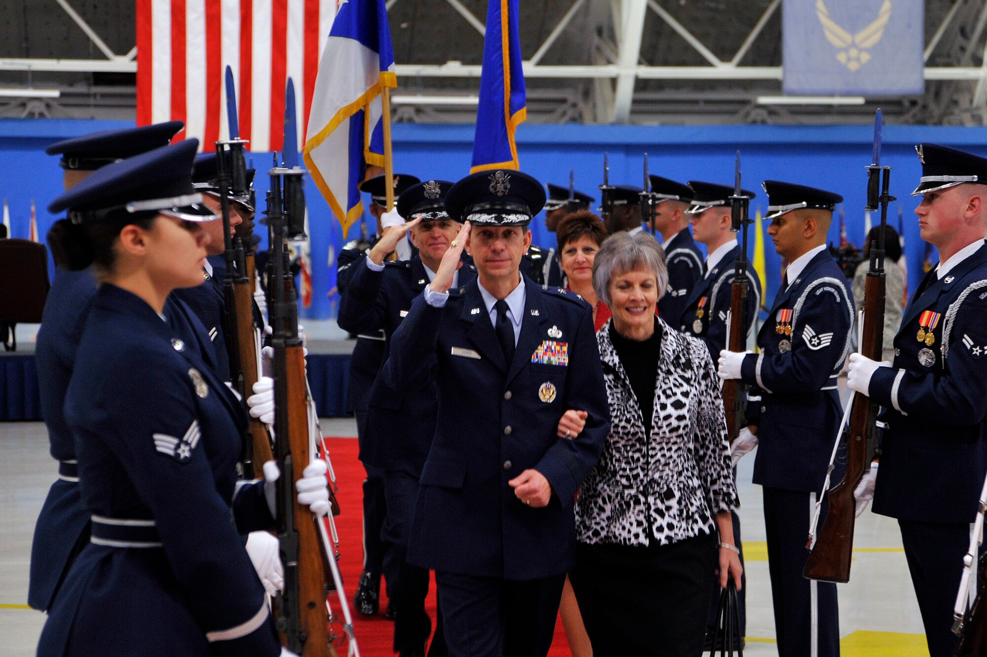 General Darrell E. Jones and his wife, Holly, exit the Change of Command ceremony arm in arm. Gen. Jones has just took command of the Air Force District of Washington on Nov. 18, 2009. To the couples left and right are members of the Air Force Honor Guard, on hand for a troop inspection by the former commander, Lt. Gen. Ralph Jodice and the incoming Commander, Gen. Jones. 