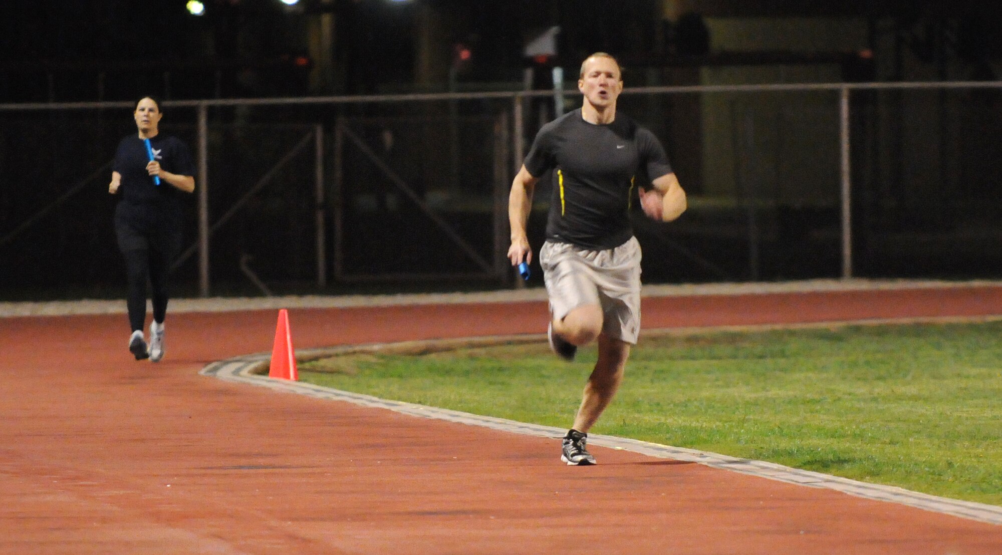 2nd Lt. Tony Bowman and Tech. Sgt. Megan Curran, 39th Operations Squadron, compete during the 4x400 relay Wednesday, Nov.18, 2009 at the Incirlik track.  The 39th Force Support Squadron and Health and Wellness Center hosted the Under the Lights track meet where squadrons from around the base could compete in various events for points toward a trophy at the end of the event.  (U.S. Air Force photo/Senior Airman Ashley Wood)  