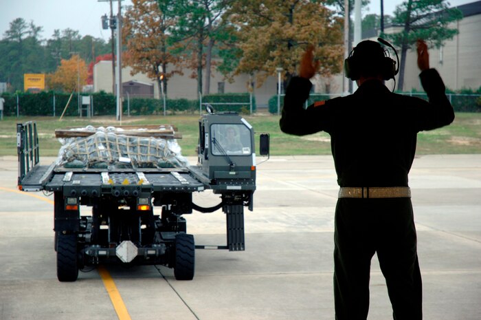 Senior Airman Travis Cox marshals a Tunner 60K Loader toward the back of a Charleston AFB C-17 at Pope AFB, N.C., while participating in the Mobility Air Forces Exercise Nov. 18. More than 40 mobility aircraft were planned for participation in MAFEX, including C-17, C-130 and KC-135 aircraft. Airman Cox is a loadmaster assigned to the 14th Airlift Squadron. (U.S. Air Force photo/Staff Sgt. Marie Brown)