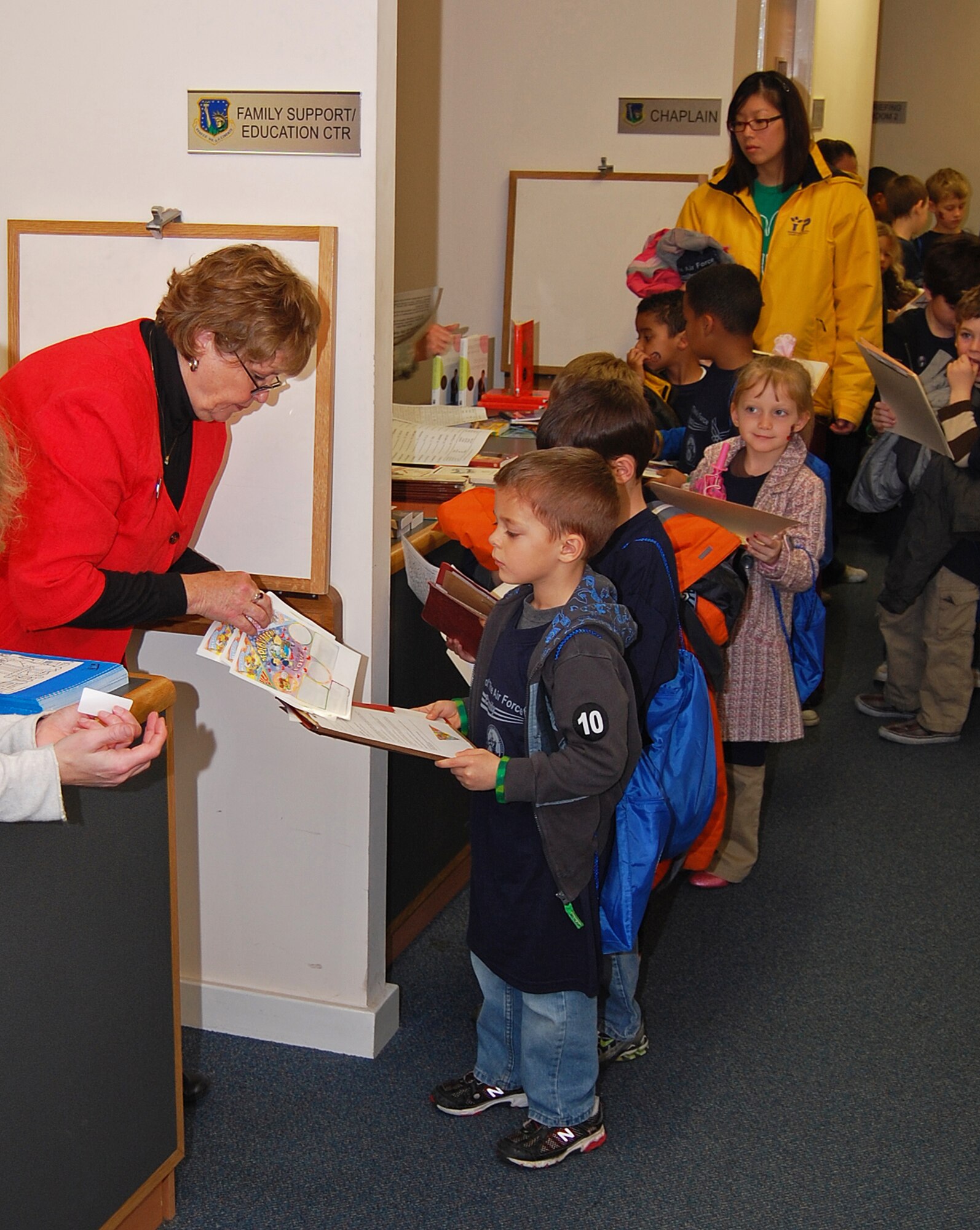 Children rotate through different stations to get their orders signed before going to their deployed location, Camp Cloudy, Iraq, on RAF Lakenheath, England, Nov. 13. The mock deployment line helped the children understand what happens when their parents deploy.  (U.S. Air Force photo by Tim Barlow)