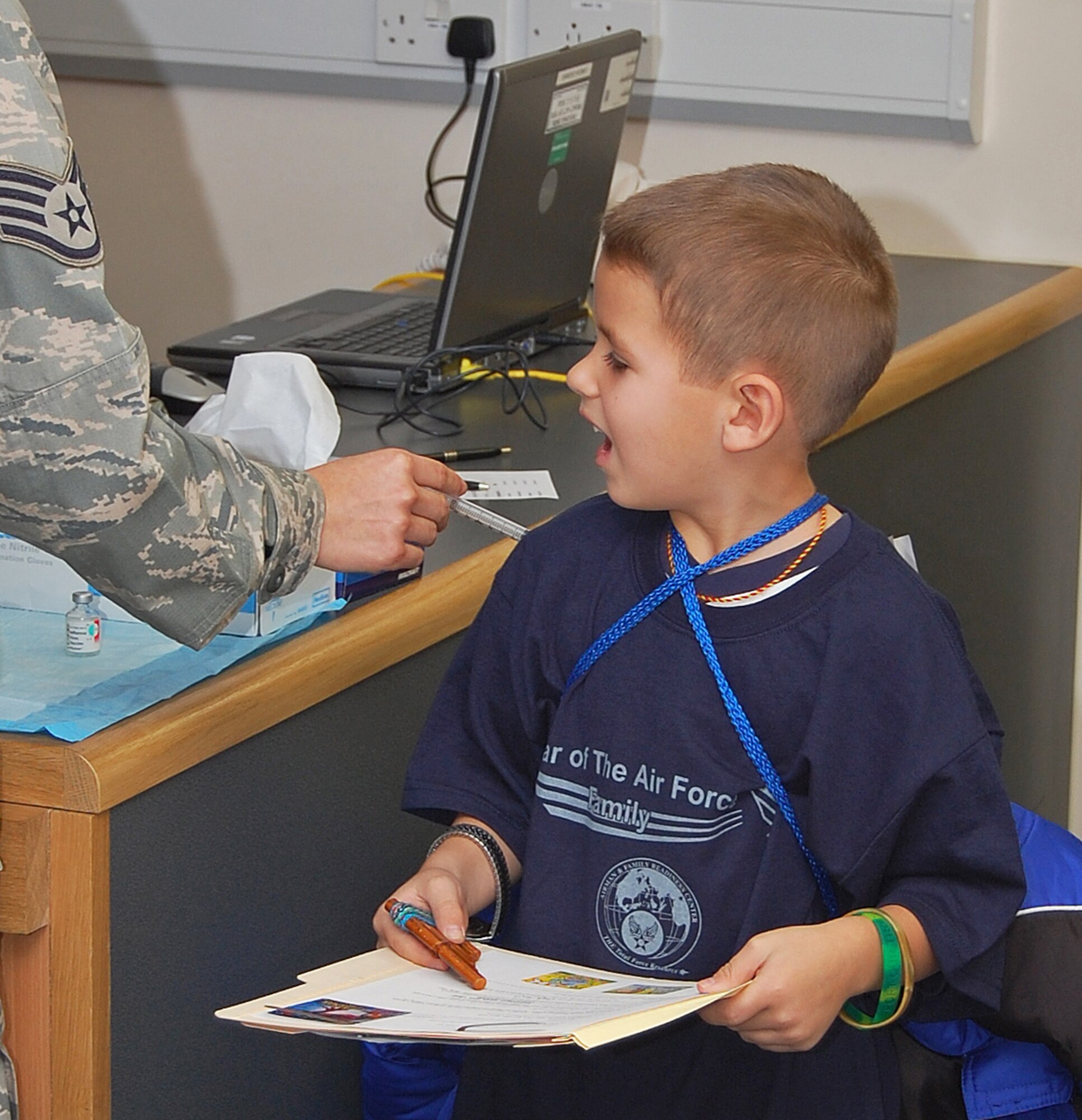 Micah Webb, age 7, gets a simulated shot during a mock pre-deployment processing line on RAF Lakenheath, England, Nov. 13. The processing line gave the children an idea of the things their parents go through before deploying.  (U.S. Air Force photo by Tim Barlow)