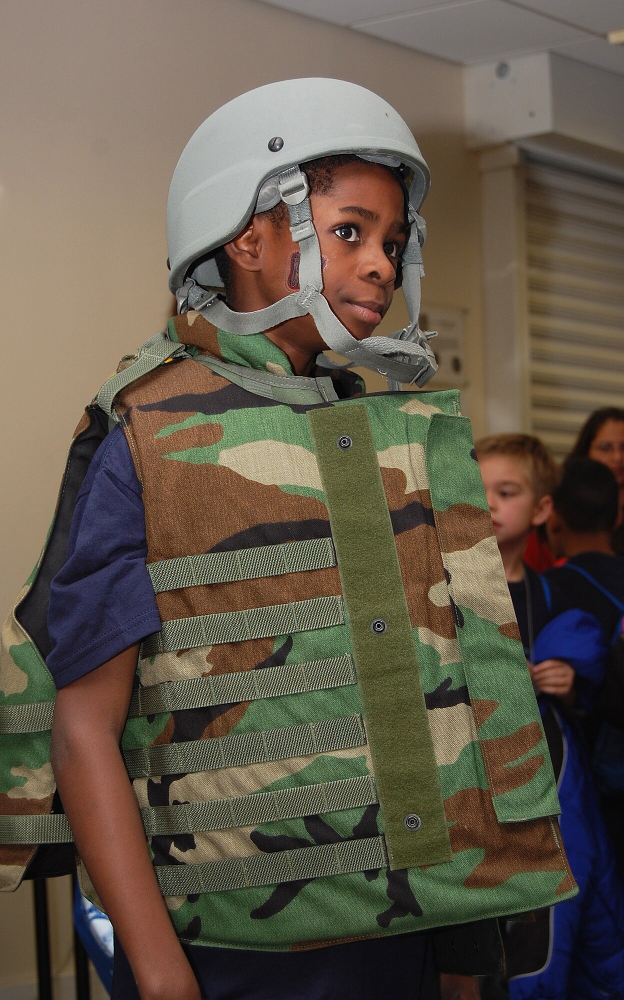 Joshua Berry, age 8, tries on a Kevlar helmet and bullet-proof vest during a mock deployment for children at RAF Lakenheath, England, Nov. 13. The children put on protective gear to simulate deploying as Liberty Warriors.  (U.S. Air Force photo by Tim Barlow)
