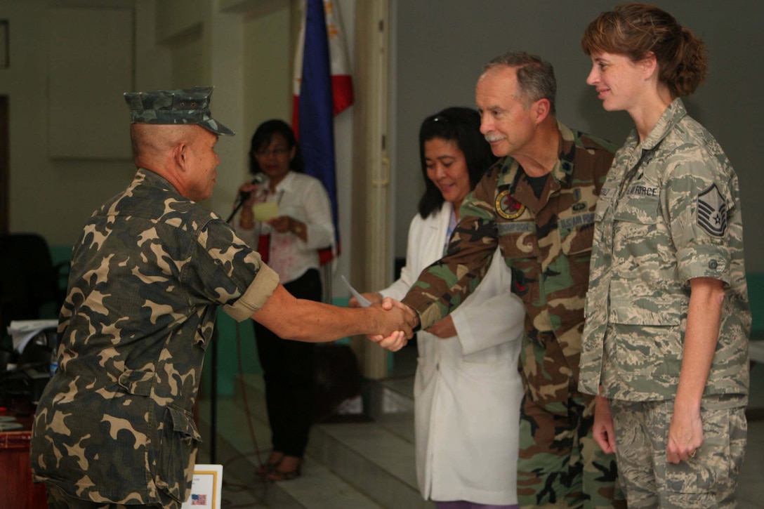 Air Force Chaplain (Lt. Col.) Steven Thompson gives a graduation certificate to an attendee at a three-day psychosocial combat stress class taught at Camp Navarro General Hospital in Zamboango, Philippines, Nov. 18, 2009. U.S. Marine Corps photo by Sgt. Jose Castellonlopez