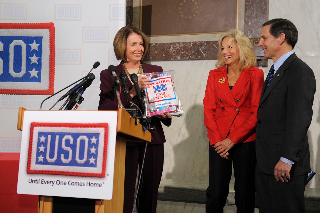 House Speaker Nancy Pelosi, left, holds up a USO care package specifically for female troops in Iraq and Afghanistan, as Dr. Jill Biden, wife of Vice President Joe Biden, and USO President and CEO Sloan Gibson watch during a Congressional Stuffing Party on Capitol Hill, Nov. 18, 2009, in Washington D.C. USO photo by Mike Theiler.