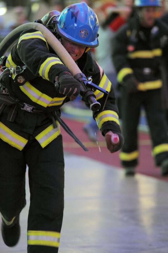 Ron Prettyman pulls a water hose as he competes in the team relay event Nov. 20, 2009, at the Scott Firefighter Combat Challenge in Las Vegas. Mr. Prettyman is a firefighter at the Air Force Academy in Colorado Springs, Colo. (U.S. Air Force photo/Staff Sgt. Desiree N. Palacios)