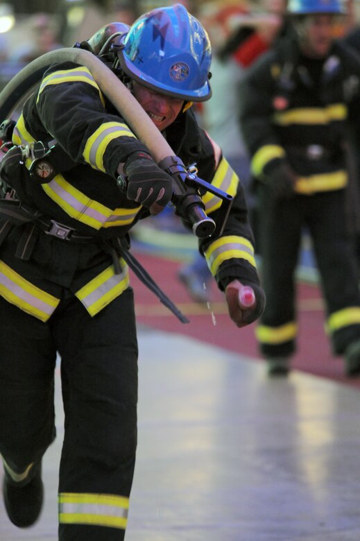 Ron Prettyman pulls a water hose as he competes in the team relay event Nov. 20, 2009, at the Scott Firefighter Combat Challenge in Las Vegas. Mr. Prettyman is a firefighter at the Air Force Academy in Colorado Springs, Colo. (U.S. Air Force photo/Staff Sgt. Desiree N. Palacios)