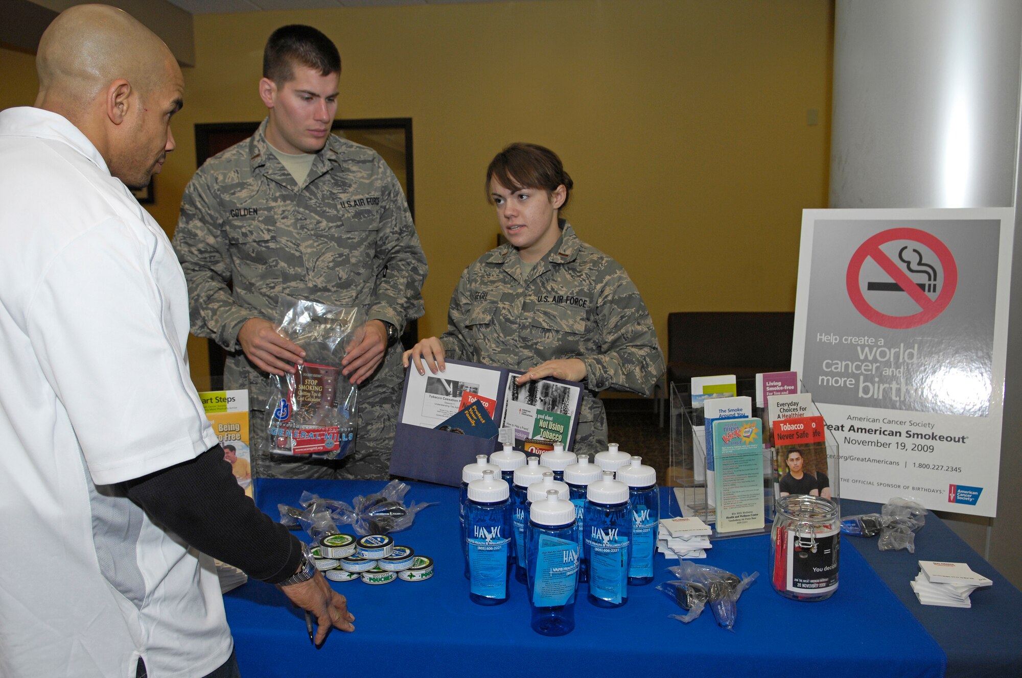 VANDENBERG AIR FORCE BASE, Calif. -- Speaking with Anthony Mitchum, a technical consultant for Vandenberg’s Phantom Fitness, is 2nd Lt. Adam Golden and 2nd Lt. Melanee Fegel, both from the 392nd Training Squadron, who were representatives at Vandenberg’s Great American Smoke Out booth at the fitness center here Thursday, Nov. 19, 2009.  The Great American Smoke Out was a day dedicated to providing the public about the health risks associated with tobacco. (U.S. Air Force photo/Airman 1st Class Andrew Lee) 