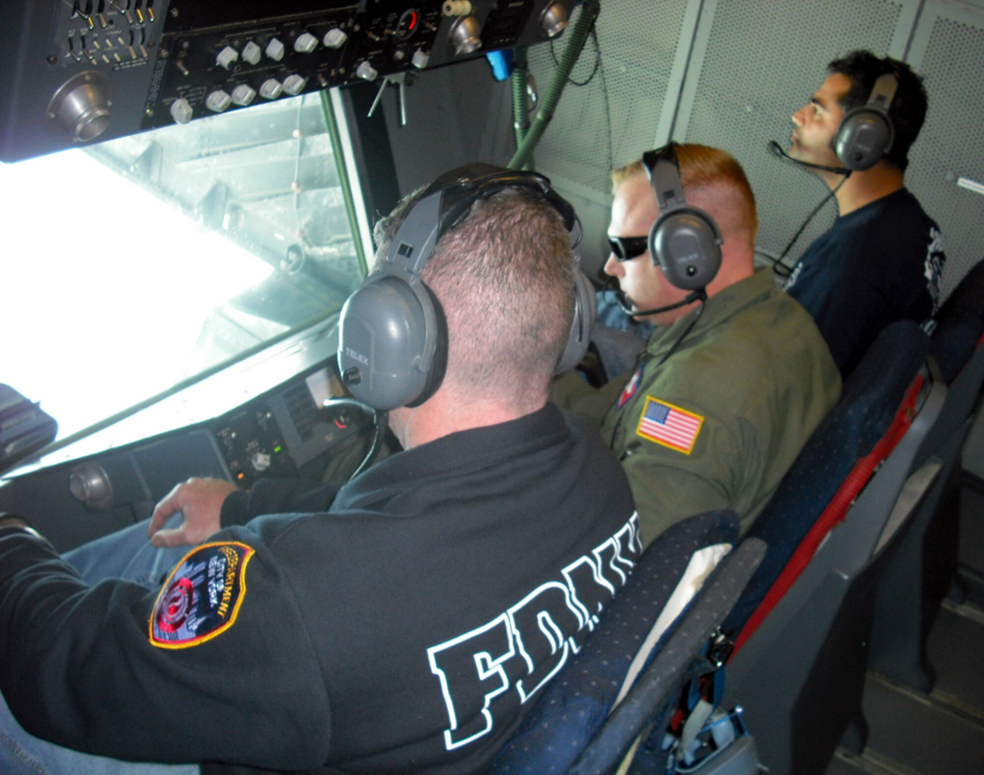 (Center) Master Sgt. Chris Sidoli, 305th Operations Support Squadron, operates the boom in a McGuire KC-10 during an aerial refueling of an F-22 Nov. 20. (Left) Wasim Husain and Robert Hickey, both New York City firemen, watched the refueling as part of a civic leader orientation flight. Seventeen NYC fire fighters, who supported the aftermath of 9/11, visited Joint Base McGuire-Dix-Lakehurst to learn more about the Air Force mission and experience firsthand what it’s like to be a U.S. Airman. (U.S. Air Force photo/Senior Airman Bekah Phy) 
