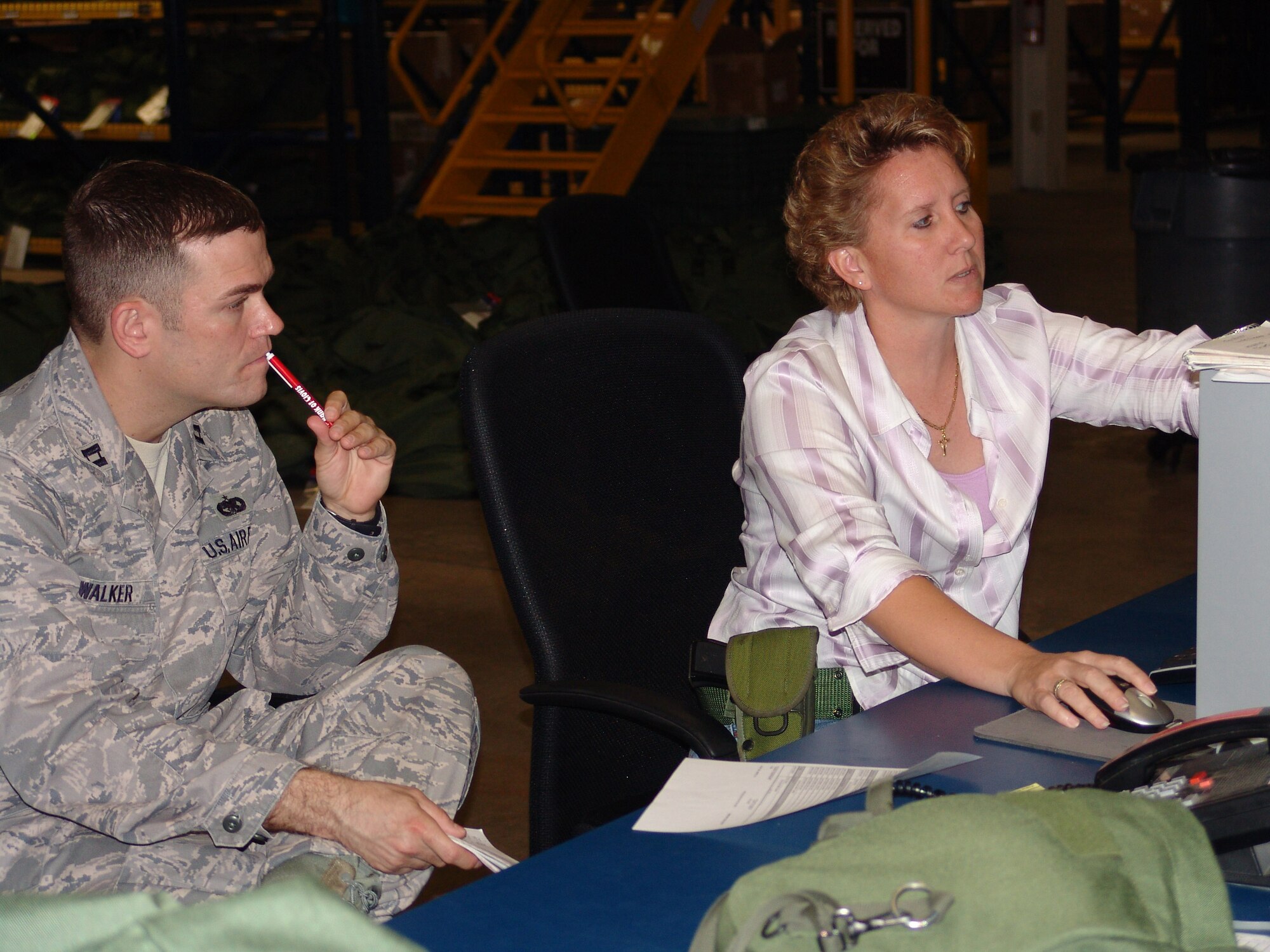 Tori Morris explains tracking deployment equipment to Capt. Todd Walker, Cannon AFB, N.M., as part of her civilian duties.  Also an individual mobilization augmentee, Senior Master Sgt. Morris was recently named Senior NCO of the Year by Air Force Reserve Command. (USAF photo/Lois Walsh)                               