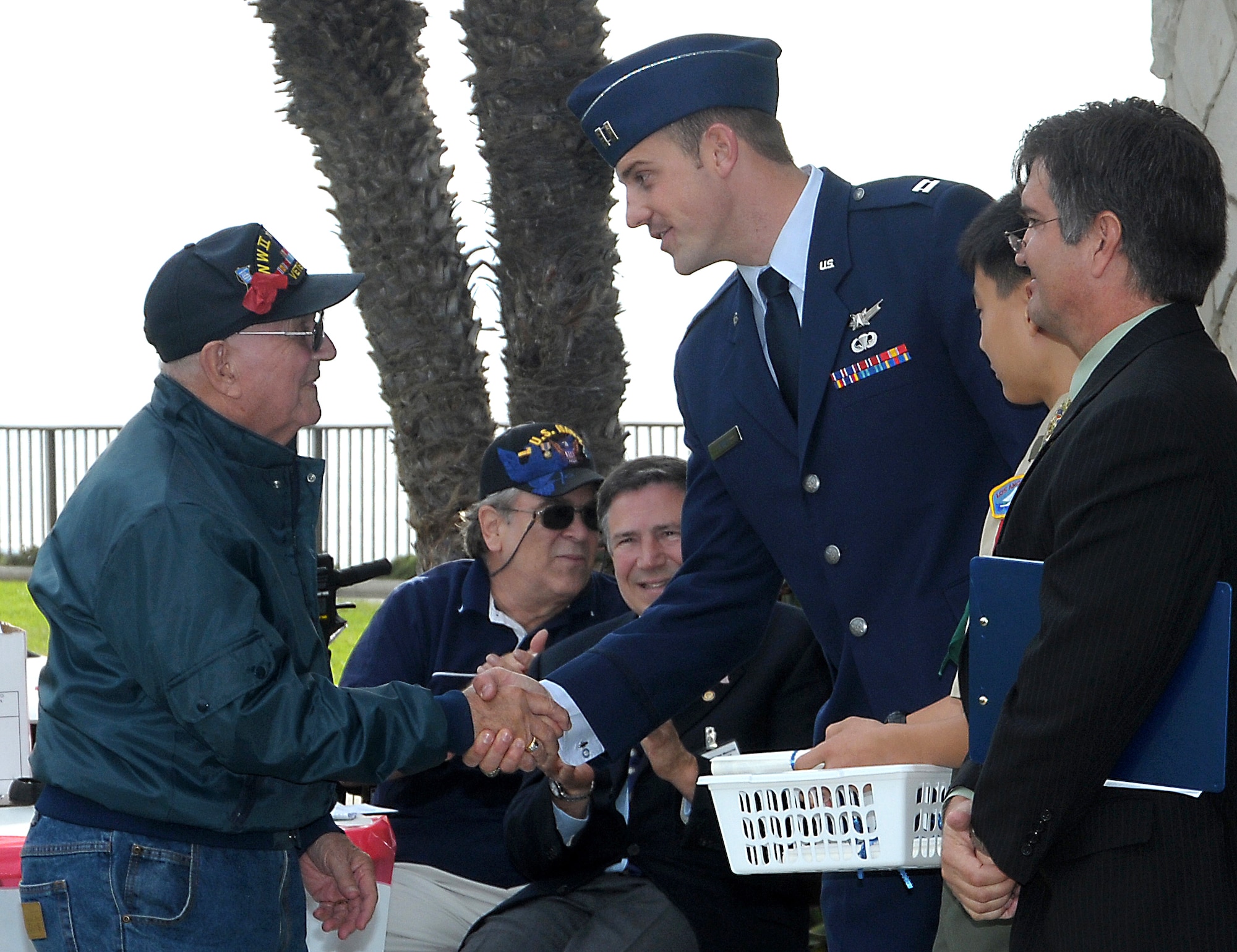 Capt. Joshua Jewett (center), Space and Missile Systems Center’s Space Base Infrared Systems Wing, greets Navy veteran Robert Rider (left) during the recognition of World War II veterans, Nov. 11. Captain Jewett was the keynote speaker during the 7th annual Veterans Day Tribute held by the City of Redondo Beach, Calif. The event honored the veterans and current military personnel of all United States wars. (Photo by Joe Juarez)