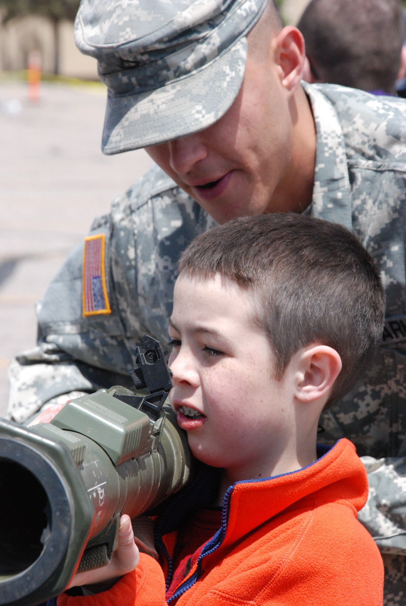 Army Private First Class Edwardo Herrera, Wyoming National Guard, instructs Brody Waters how to use an anti-tank weapon outside of the Frontier Mall May 15 during an Armed Forces Day event. The exhibit also showcased other weapons in the Army arsenal. (U.S. Air Force photo/Senior Airman Daryl Knee) 