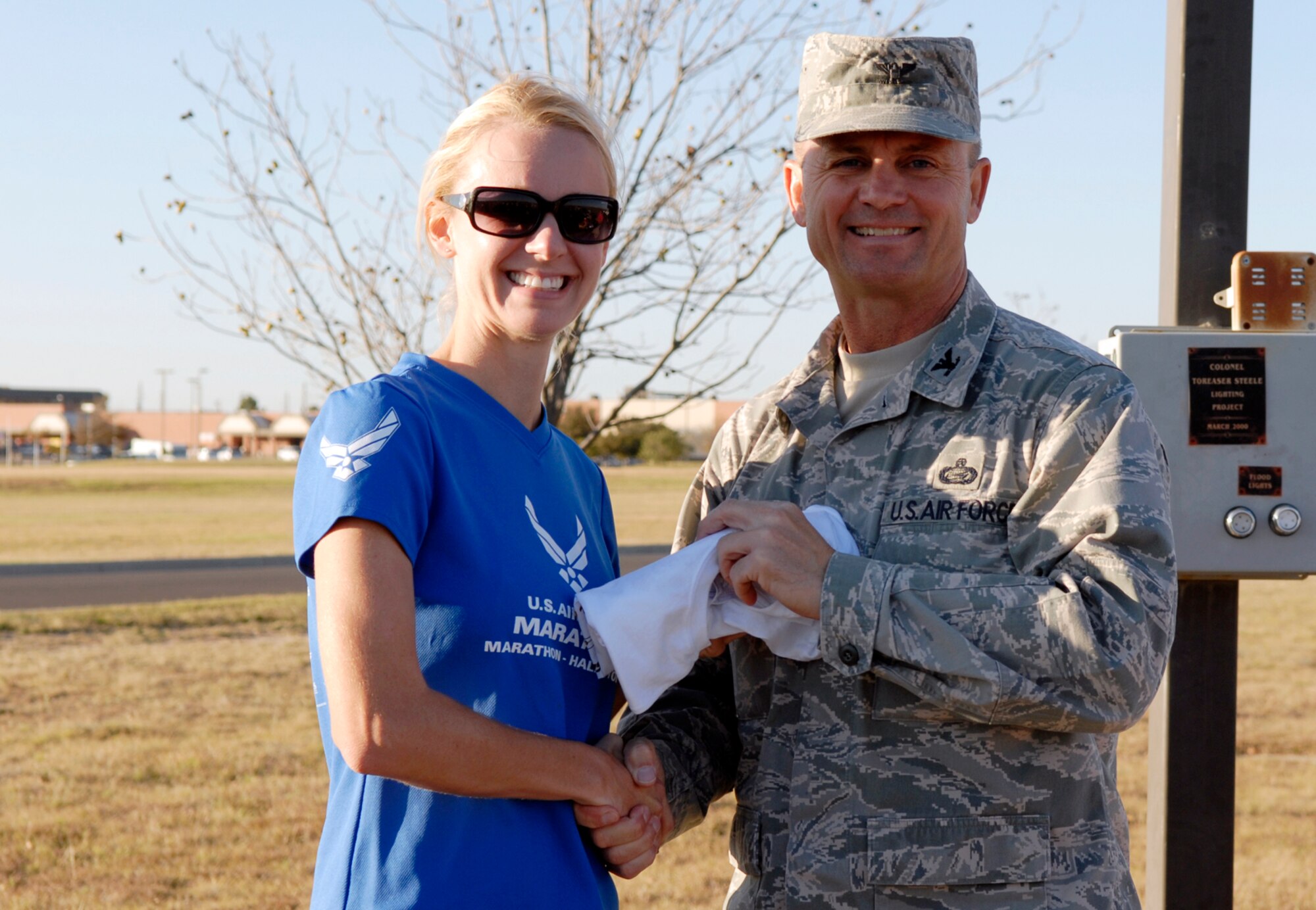 GOODFELLOW AIR FORCE BASE, Texas -- Col. Guy Parker, Commander, 17th Mission Support Group, congratulates Ruthie Kreuzer for placing first in the women's category of the 2009 Turkey Trot, Nov. 18. Ms. Kreuzer, who ran the 5 kilometer course in 15 minutes, 13 seconds, is married to Capt. Michael Kreuzer from the 315th Training Squadron. (U.S. Air Force photo/Lou Czarnecki)