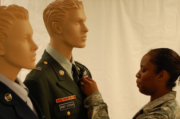 Master Sgt. Nicole Bristol adjusts the uniform of a mannequin used to
help demonstrate the proper wear of the Army service dress uniform. Sgt.
Bristol is a Reservist with the 514th Airlift Wing, but is currently
deployed to the Air Force Mortuary Affairs Operations Center, Dover Air
Force Base, Del.
