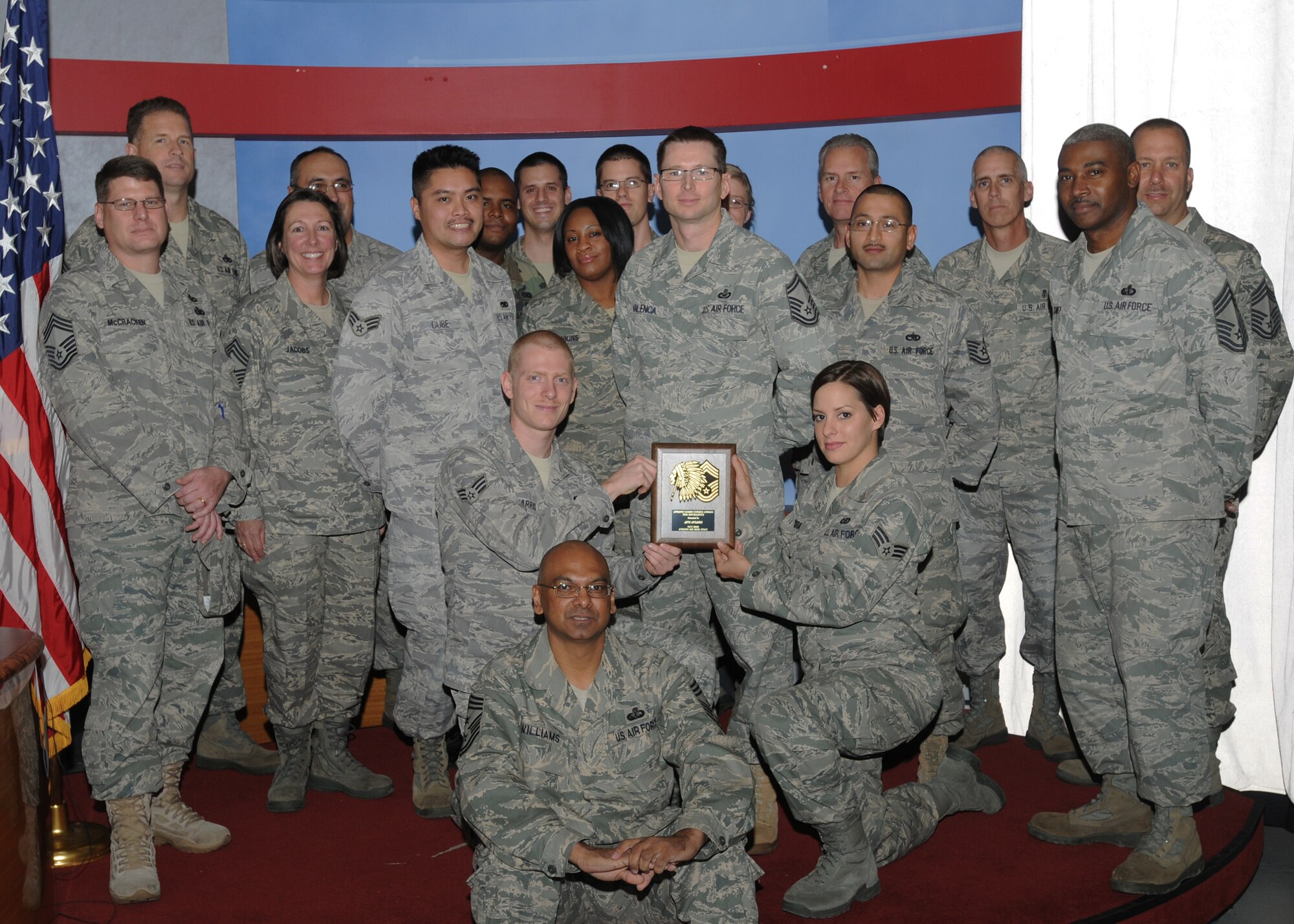 The American Forces Network-Aviano affiliate received the Aviano Chief's Choice Award for October 2009.  Chief Master Sgt. Laten Williams, 31st Fighter Wing command chief, (bottom center) and other Aviano Air Base chief master sergeants presented the award. (U.S. Air Force photo/Airman LaVel D. Sterling)