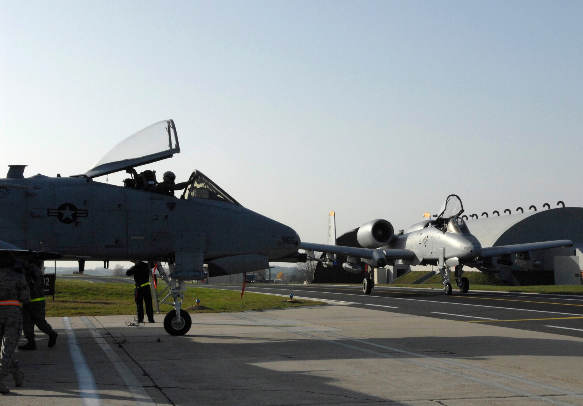 SPANGDHALEM AIR BASE, Germany – An A-10 Thunderbolt II goes through a post-flight inspection near Hardened Aircraft Shelter 2 as another A-10 taxis past Nov. 20. The A-10s were part of a six-ship aircraft formation that flew to a simulated deployed location during Operation Saber Crown 10-02. (U.S. Air Force photo/Senior Airman Kali L. Gradishar)