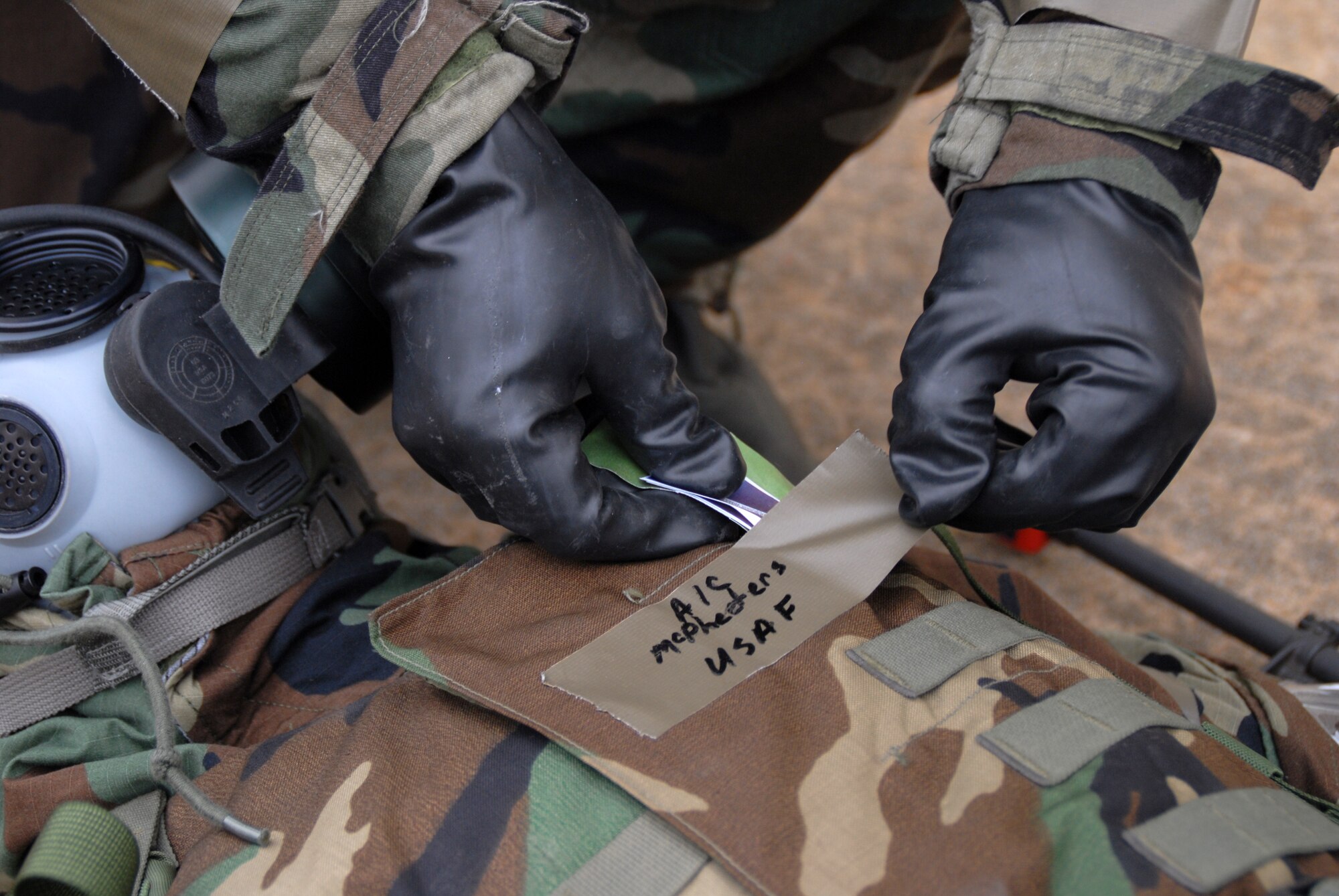 Master Sgt. Carl Hendricks, 19th Equipment Maintenance Squadron aerospace ground equipment craftsman, places two simulated atropine injectors on the vest of Airman 1st Class Joshua Mcpheeters, 19th Logistics Readiness Squadron logistic planner, so other airmen are aware that he has already been treated Nov. 17. (U.S. Air Force photo by Senior Airman Michael Watkins)