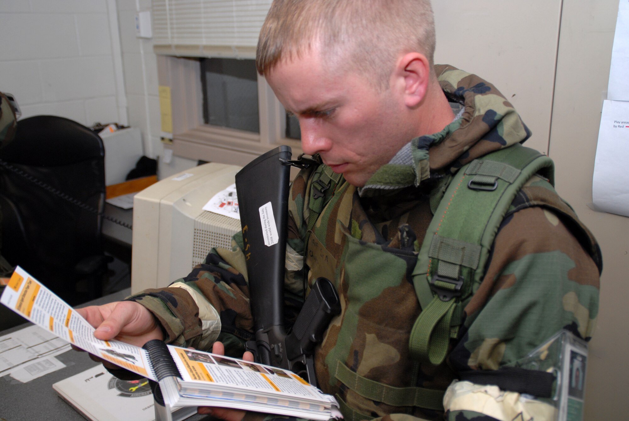 Airman 1st Class Matthew Chappell, 19th Aircraft Maintenance Squadron aircraft hydraulic systems apprentice, takes time to look through his Airman’s Manual to refresh his memory on nuclear attack and radioactive individual protective actions during a base exercise Nov. 17. (U.S. Air Force photo by Senior Airman Michael Watkins)