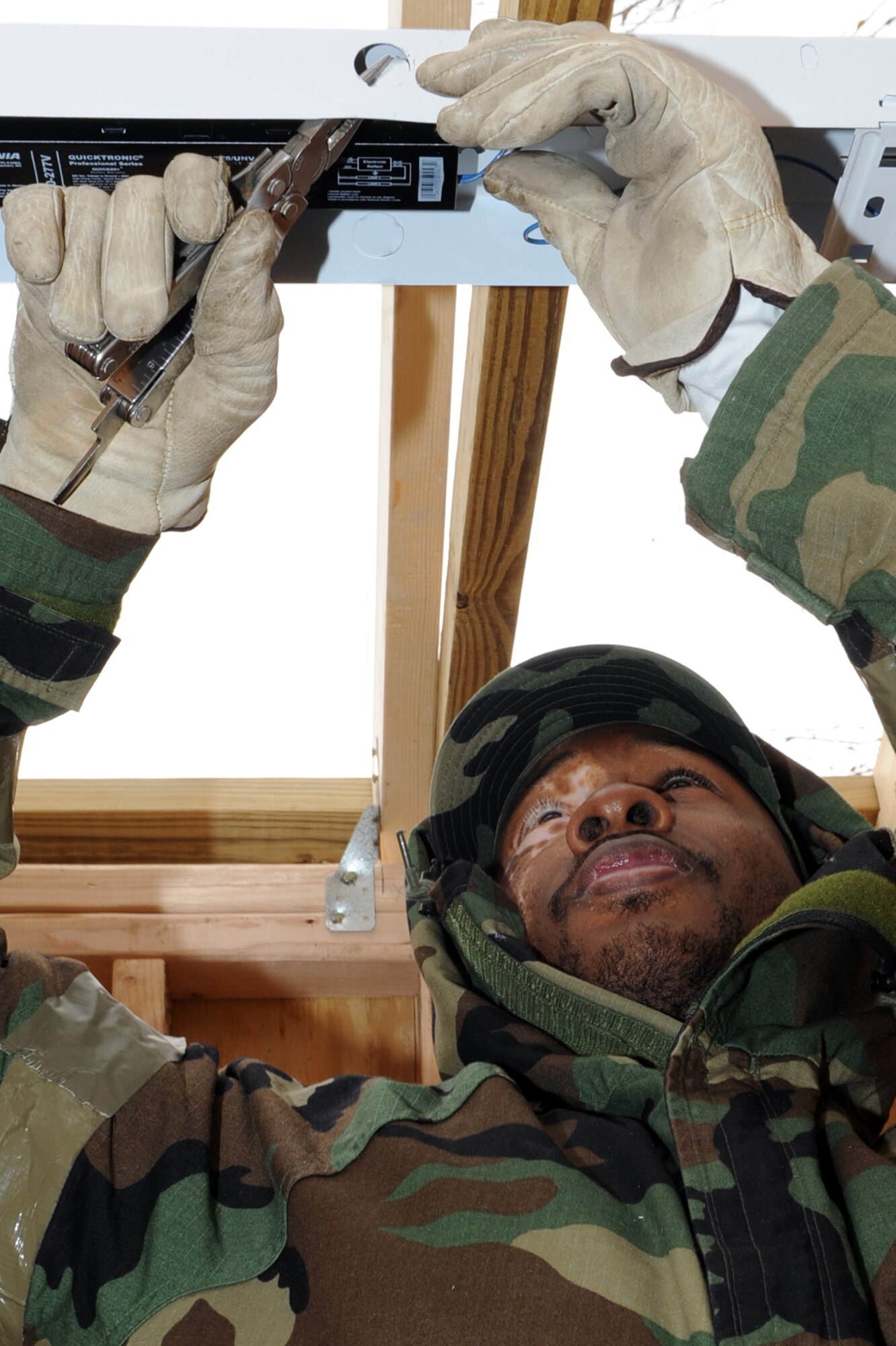 Staff Sgt. Anthony Forrester, 19th Civil Engineer Squadron electrical systems craftsman, prepares a light fixture to have a conduit run to it for new restrooms at the base lake Nov. 17. (U.S. Air Force photo by Senior Airman Ethan Morgan)